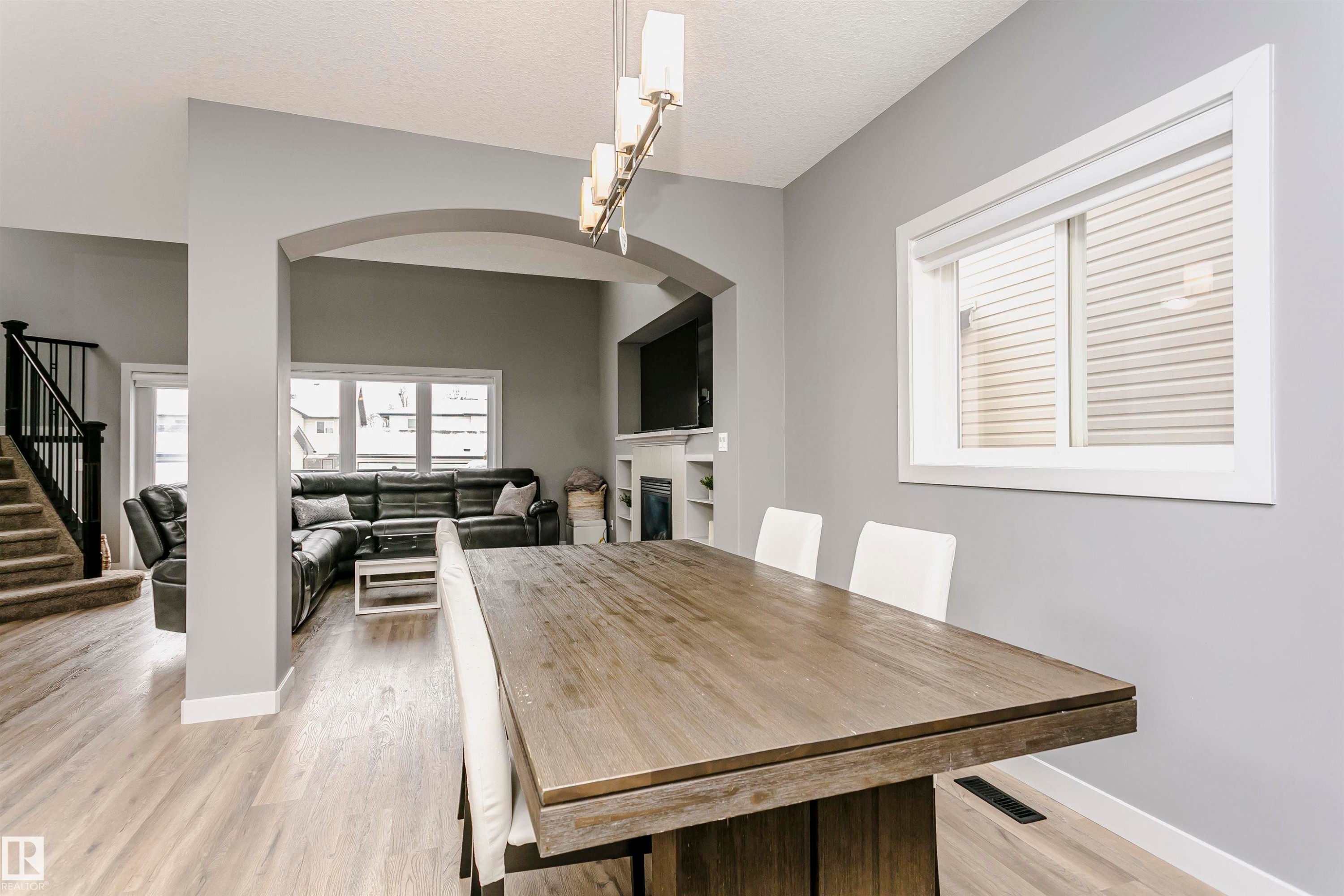 Dining area featuring light wood-style flooring, a window with blinds, and an archway leading to another living space - 21807 97 Avenue, Edmonton, AB - Indoor Photo Showing Dining Room