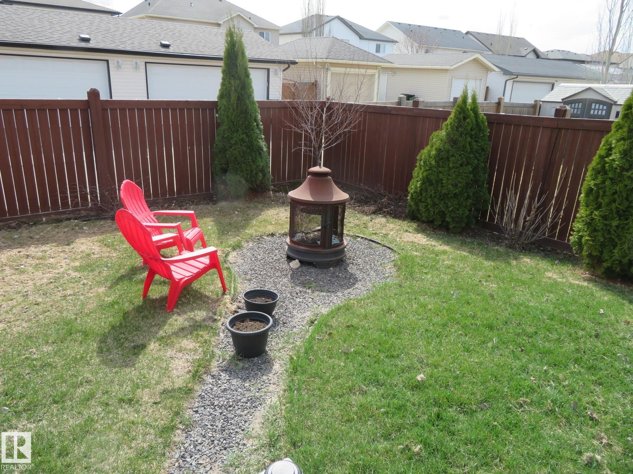Private backyard featuring a wood privacy fence, a stone-lined gravel path, and perimeter plantings - 21807 97 Avenue, Edmonton, AB - Outdoor