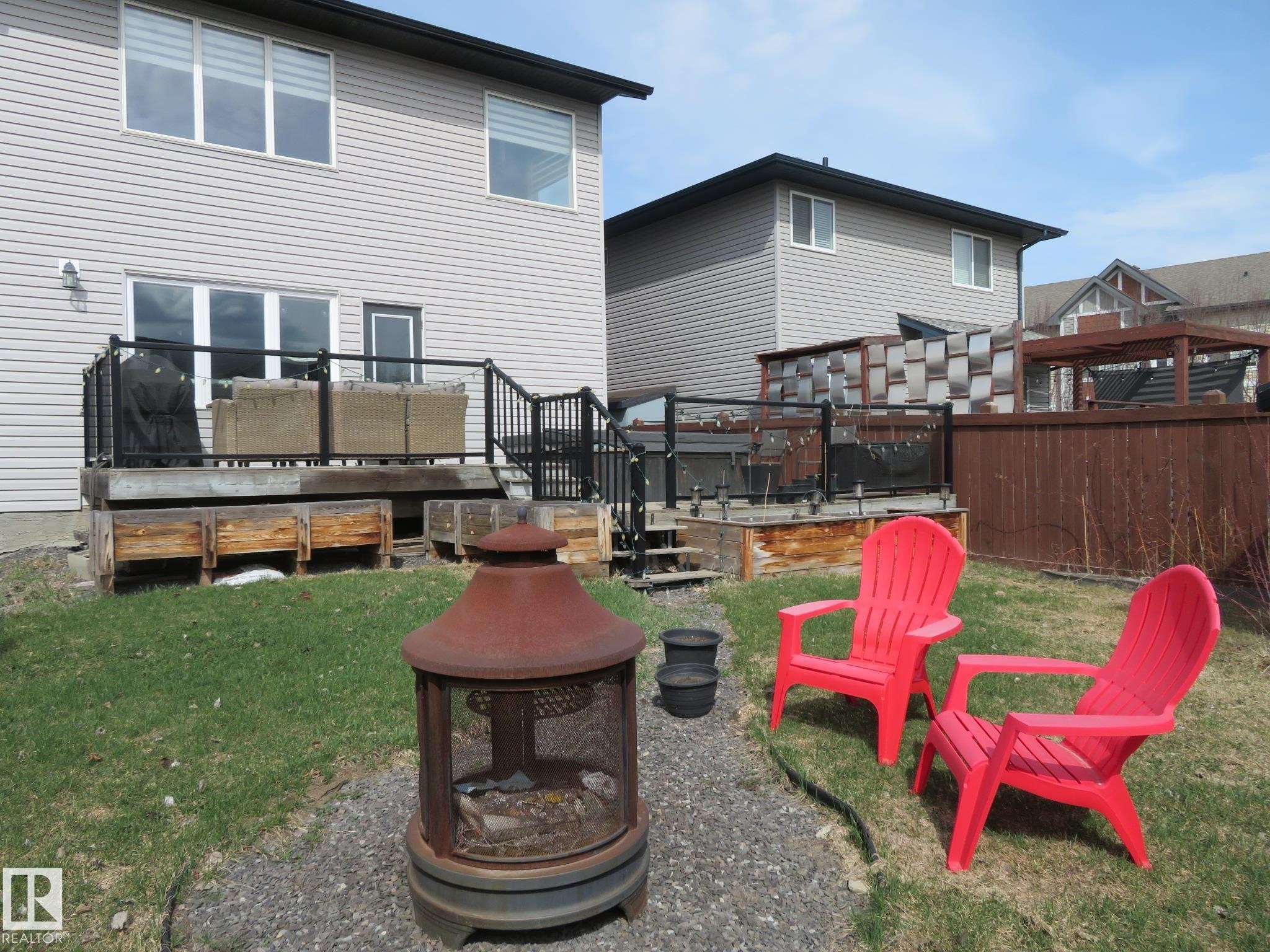 Rear exterior featuring light-toned horizontal siding and a multi-level deck with black railings - 21807 97 Avenue, Edmonton, AB - Outdoor With Deck Patio Veranda With Exterior