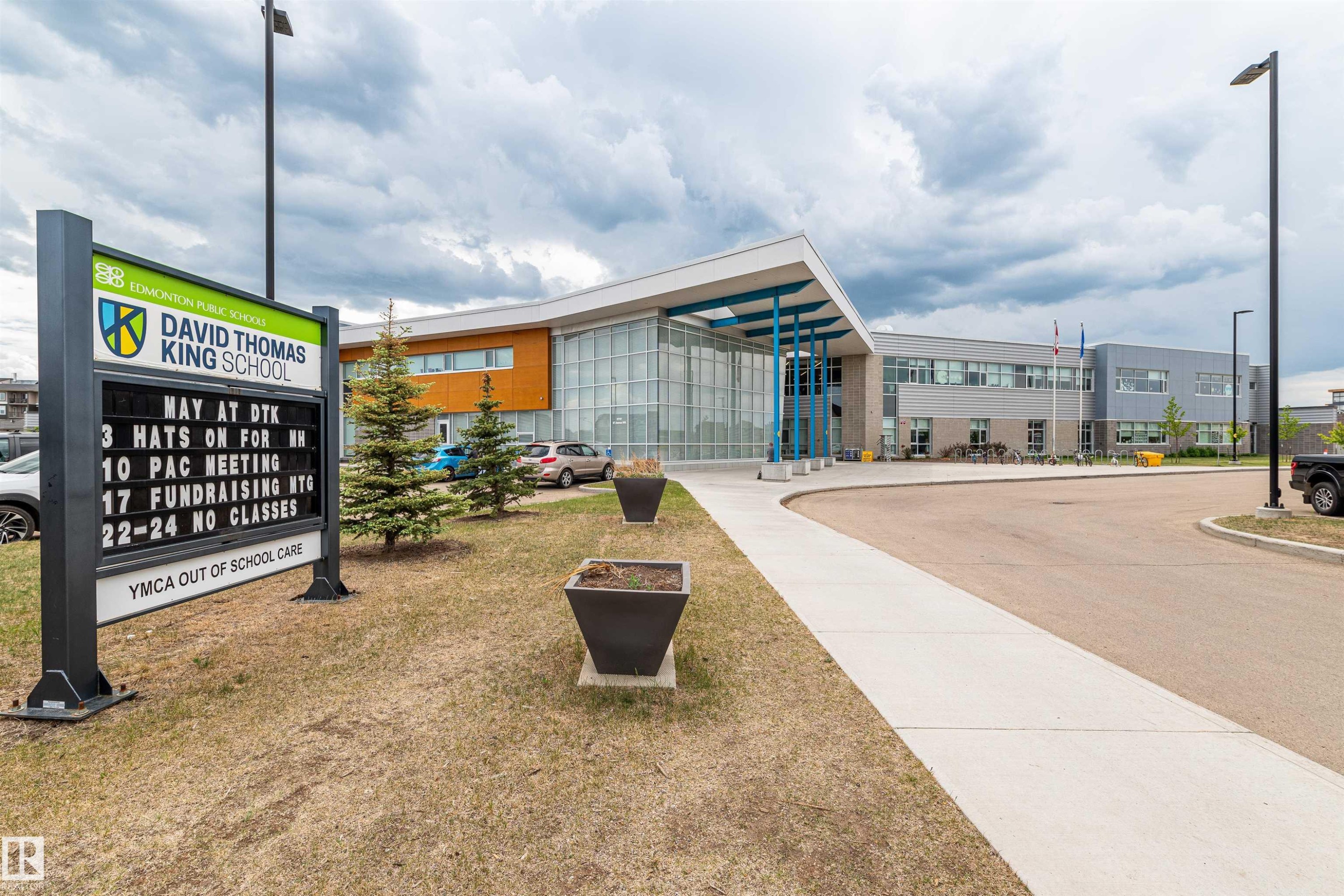 The property is located within close proximity to David Thomas King School, featuring modern architecture with a prominent glass facade and a welcoming entrance - 21807 97 Avenue, Edmonton, AB - Outdoor