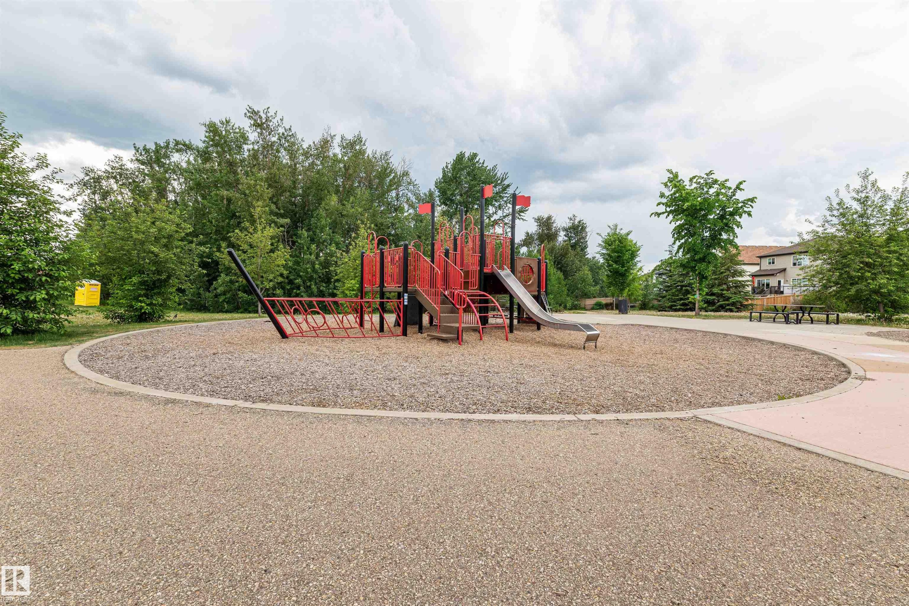 Community playground area featuring a play structure with a slide, surrounded by mature trees - 21807 97 Avenue, Edmonton, AB - Outdoor