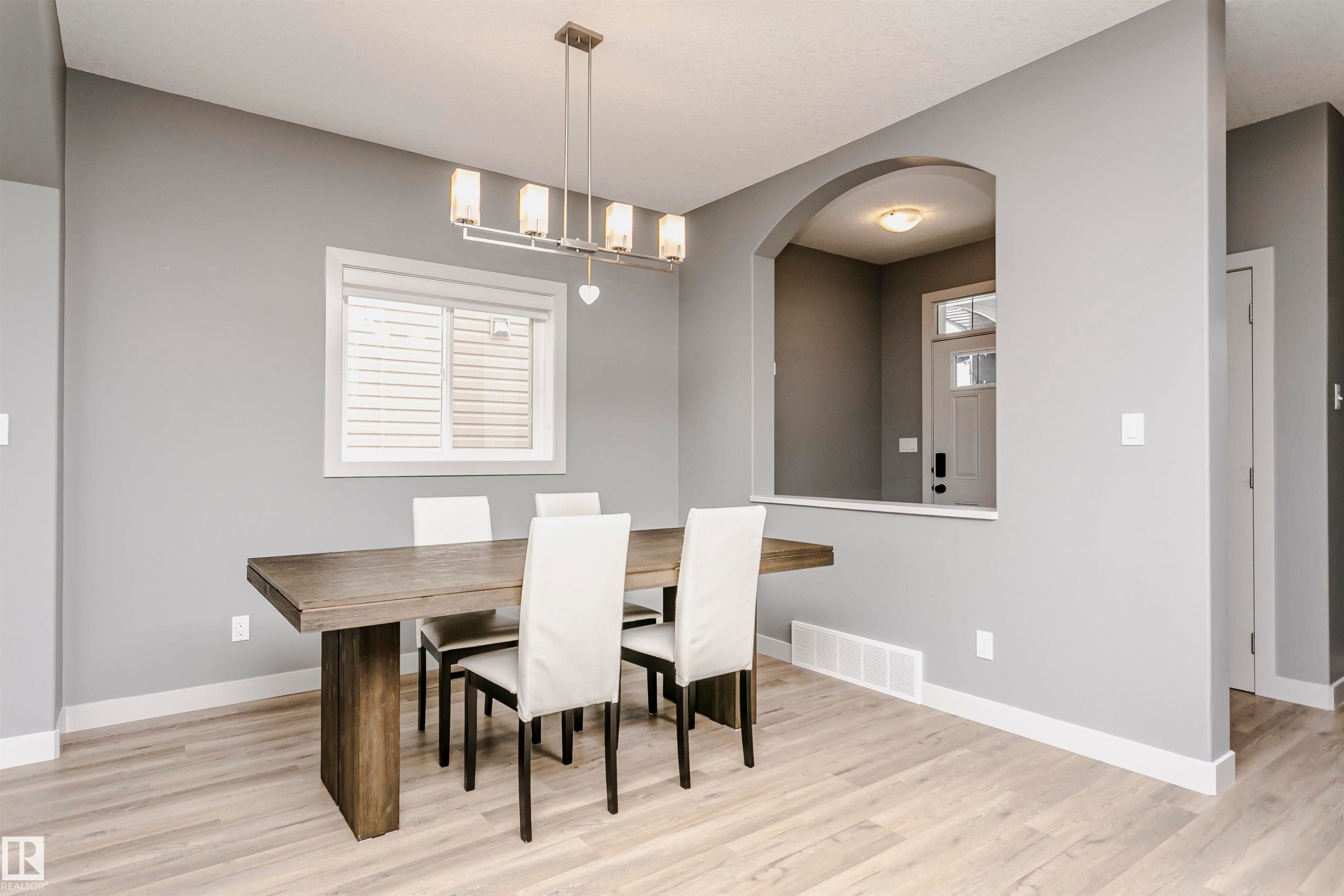 The dining area features light-colored flooring, a modern chandelier, and light gray walls - 21807 97 Avenue, Edmonton, AB - Indoor Photo Showing Dining Room