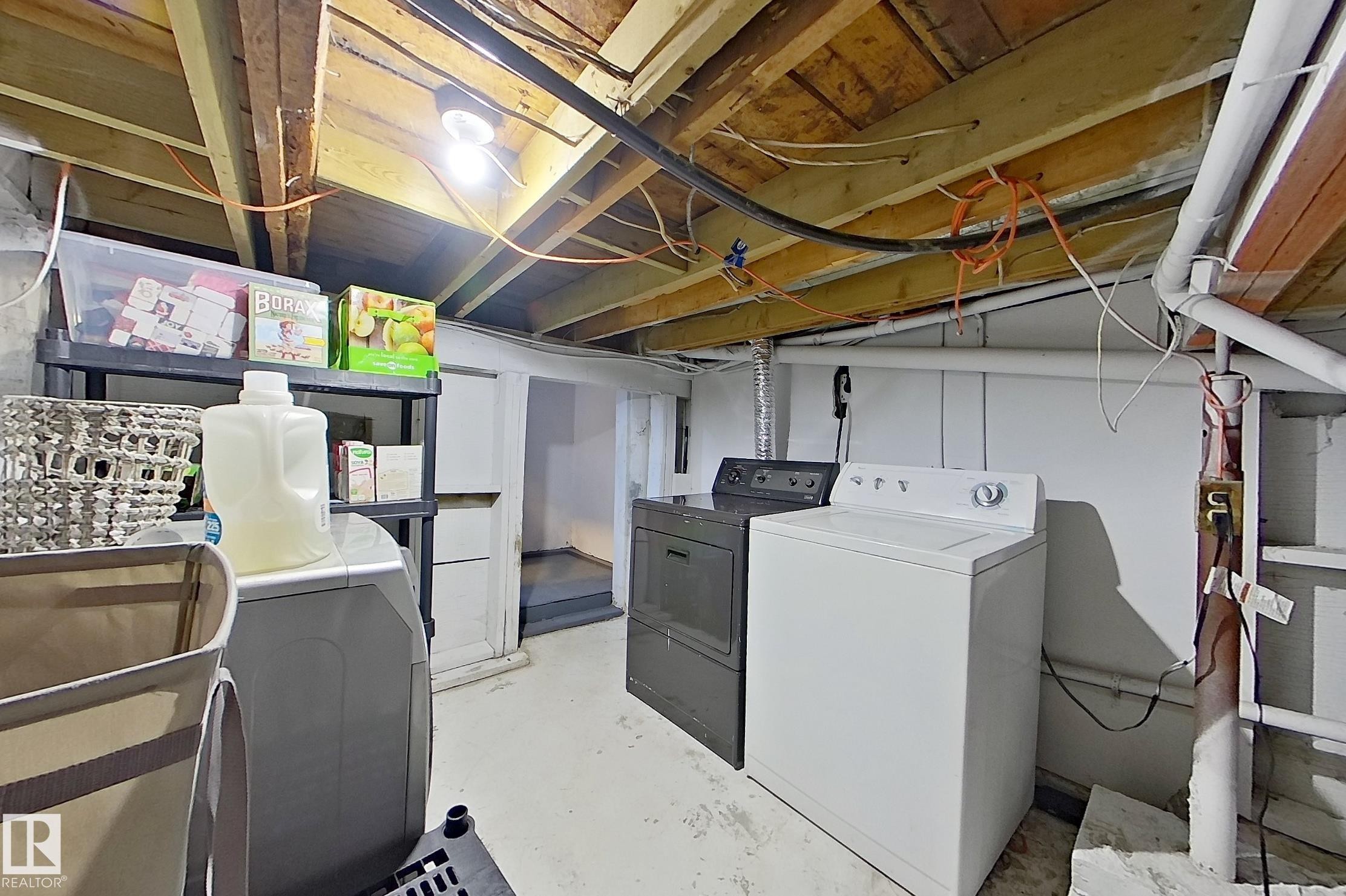 Dedicated laundry area with a white washing machine and a dark-colored dryer - 9328 106A Avenue, Edmonton, AB - Indoor Photo Showing Laundry Room
