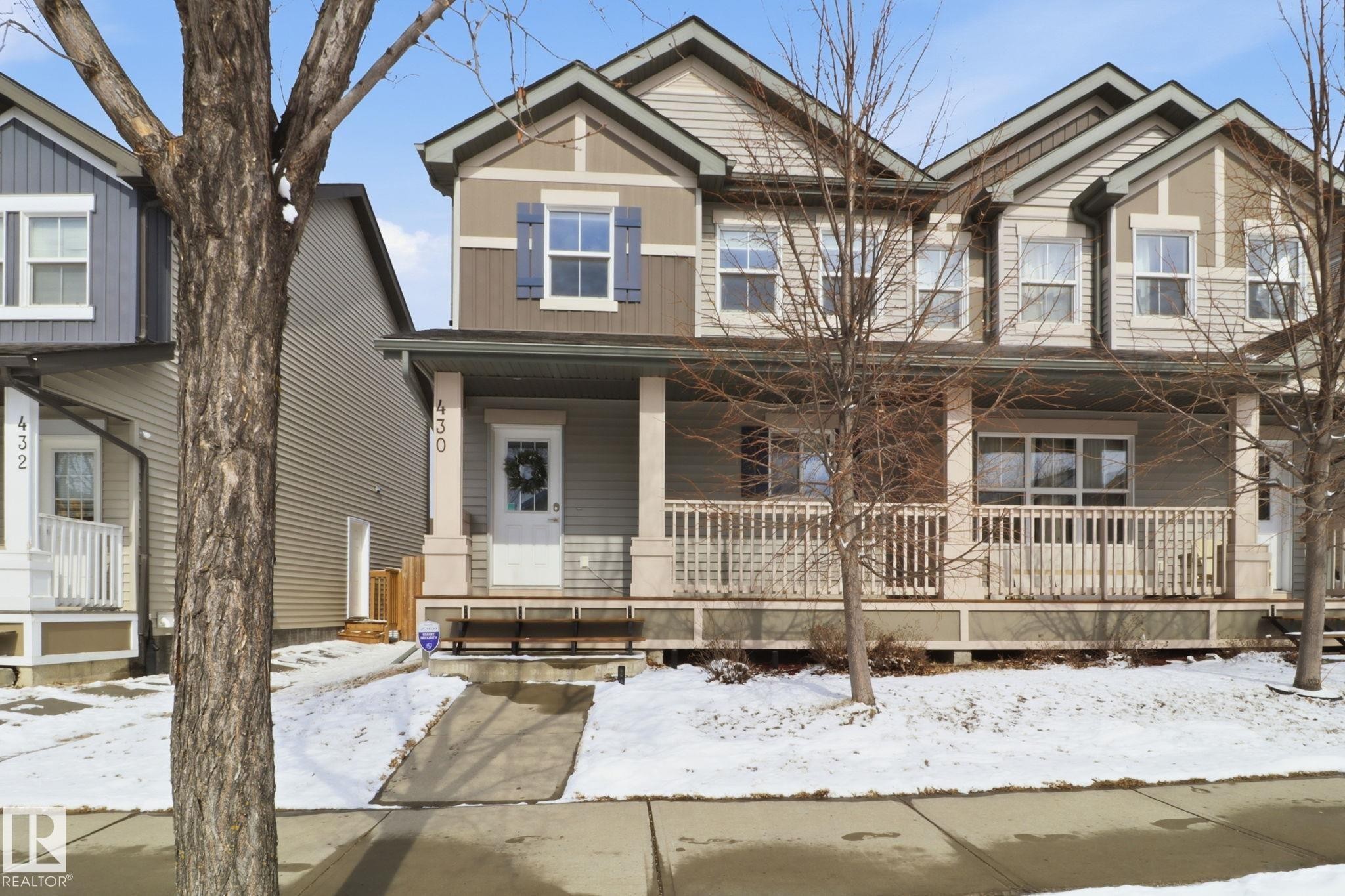 The property presents an inviting facade with a covered front porch featuring white railing - 430 Watt Boulevard, Edmonton, AB - Outdoor With Deck Patio Veranda With Facade