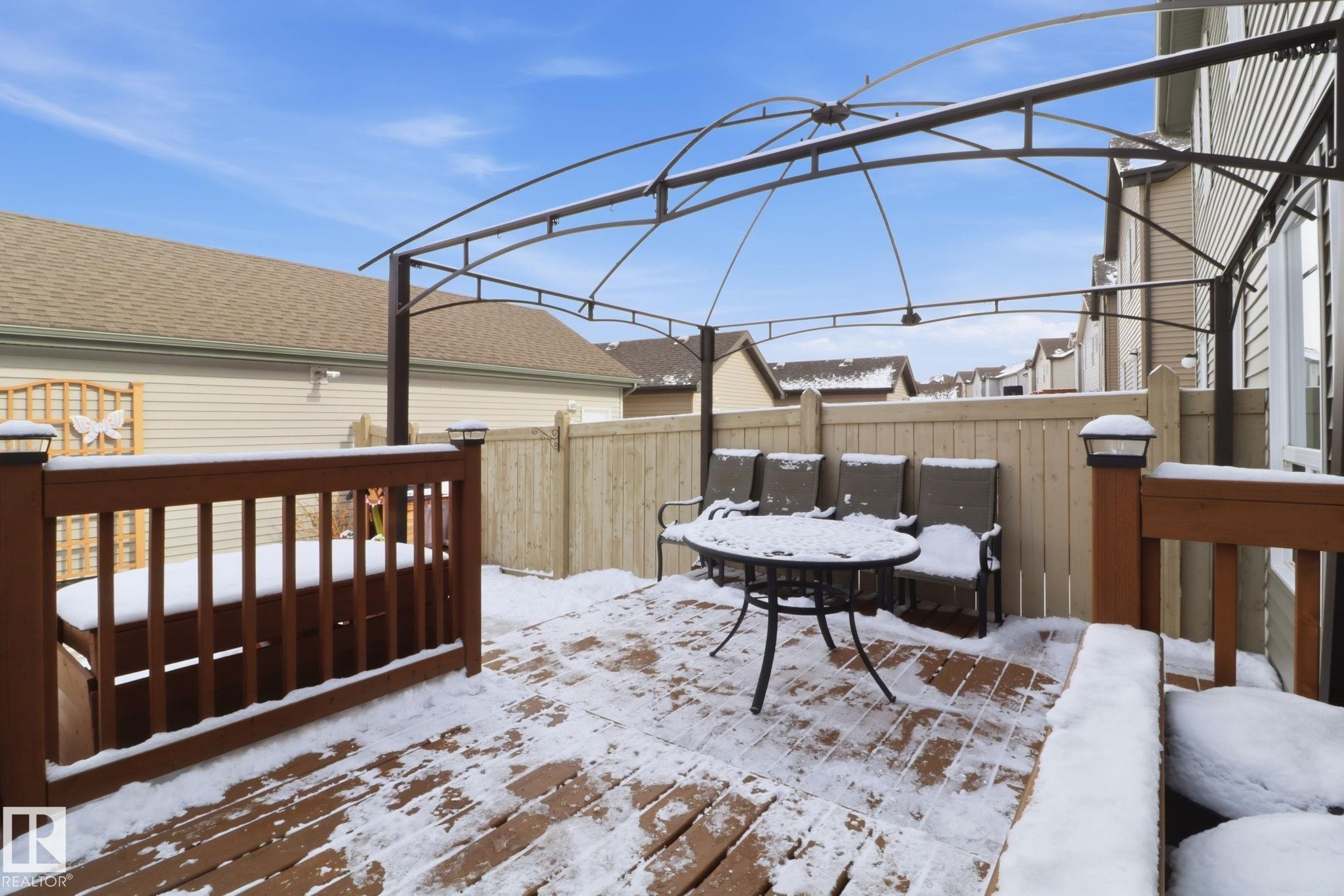The property features a wooden deck with a brown railing, a privacy fence, and a metal pergola structure - 430 Watt Boulevard, Edmonton, AB - Outdoor With Deck Patio Veranda