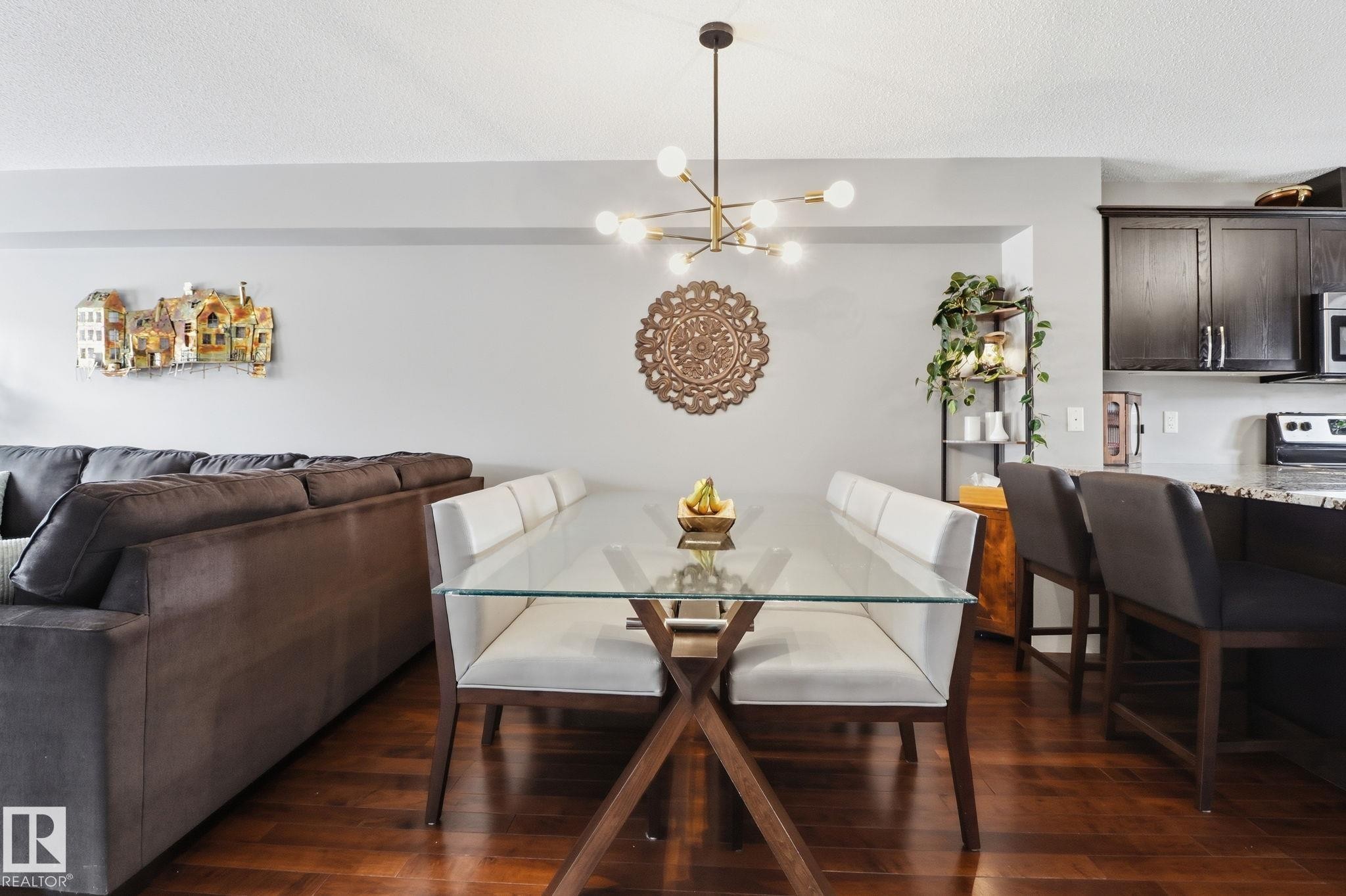 The dining area features hard wood flooring and a modern chandelier, creating a refined atmosphere - 430 Watt Boulevard, Edmonton, AB - Indoor Photo Showing Dining Room