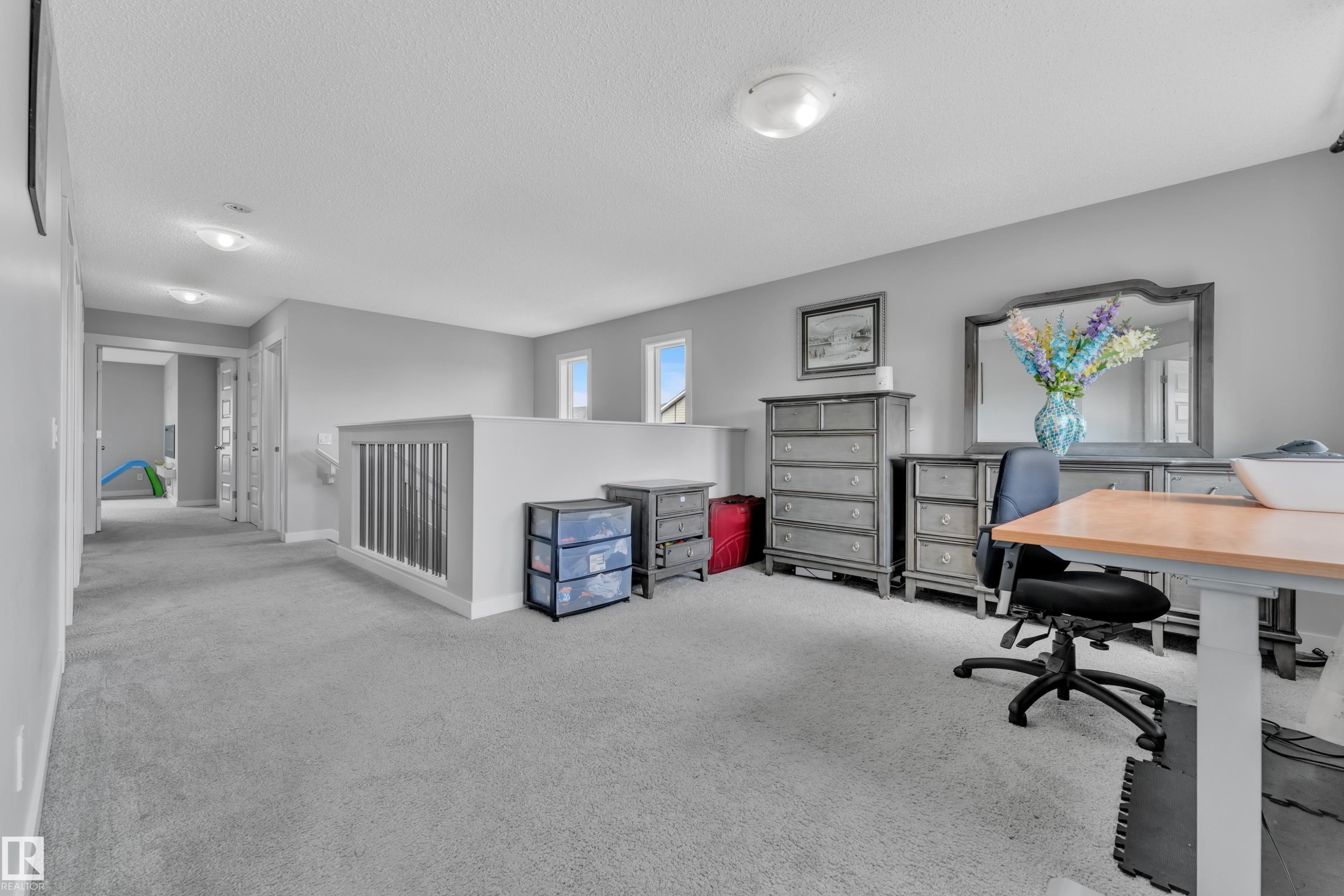 This spacious second-floor landing features neutral gray carpeting and walls, offering a versatile space - 1452 30 Street, Edmonton, AB - Indoor Photo Showing Office