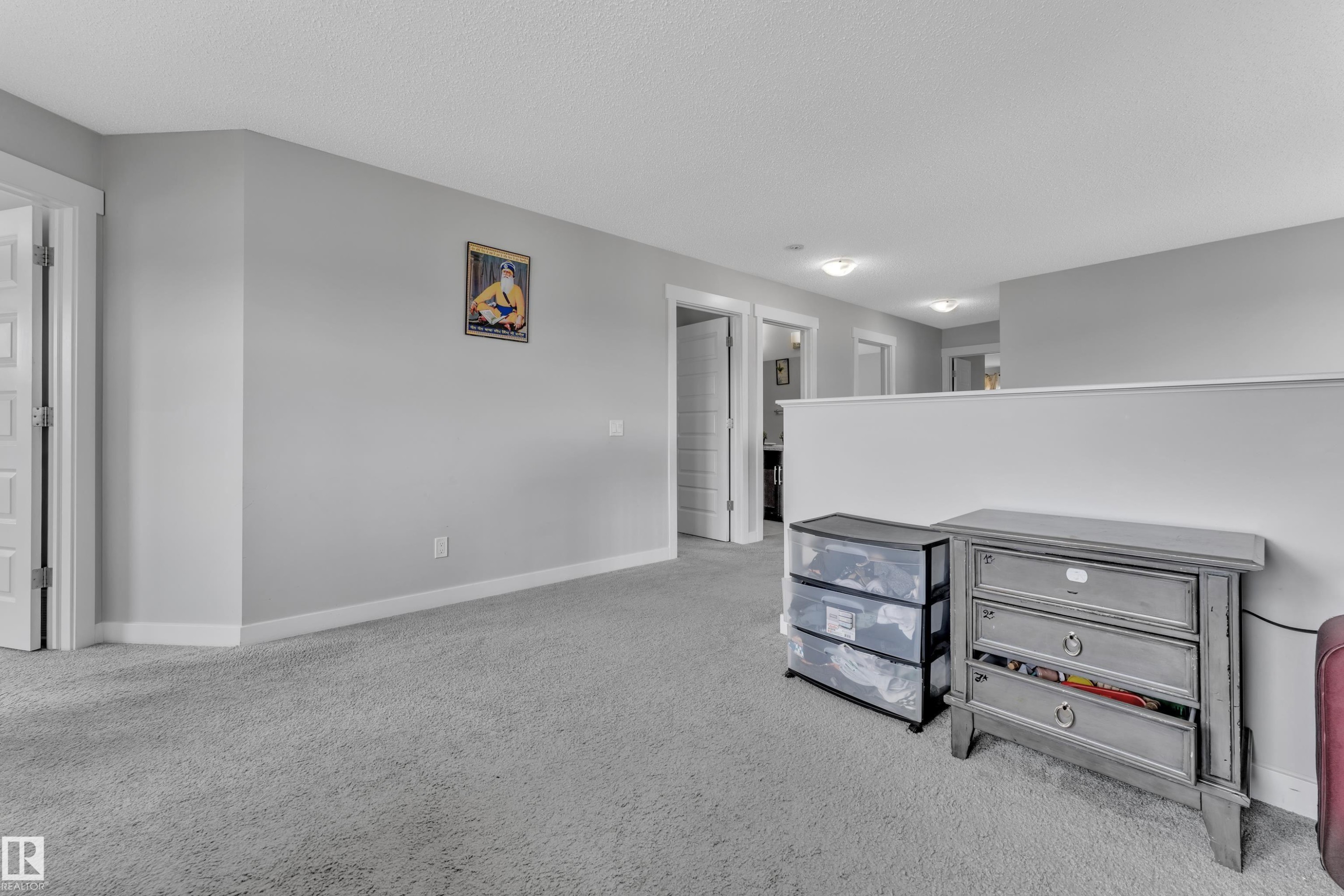This interior space features light grey walls and light grey carpeting, providing a neutral aesthetic - 1452 30 Street, Edmonton, AB - Indoor
