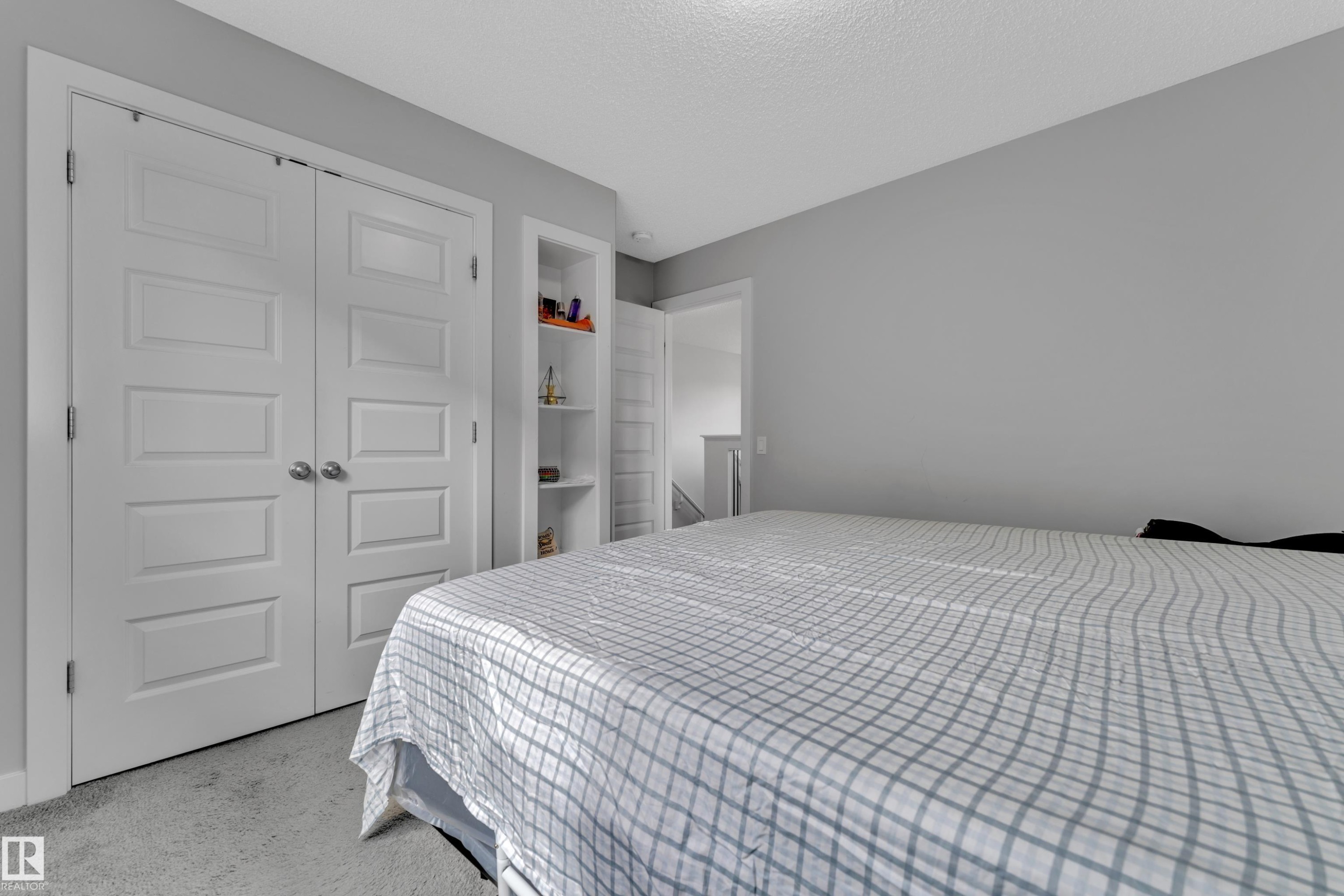 This room features neutral gray wall paint, recessed shelving, and paneled closet doors - 1452 30 Street, Edmonton, AB - Indoor Photo Showing Bedroom
