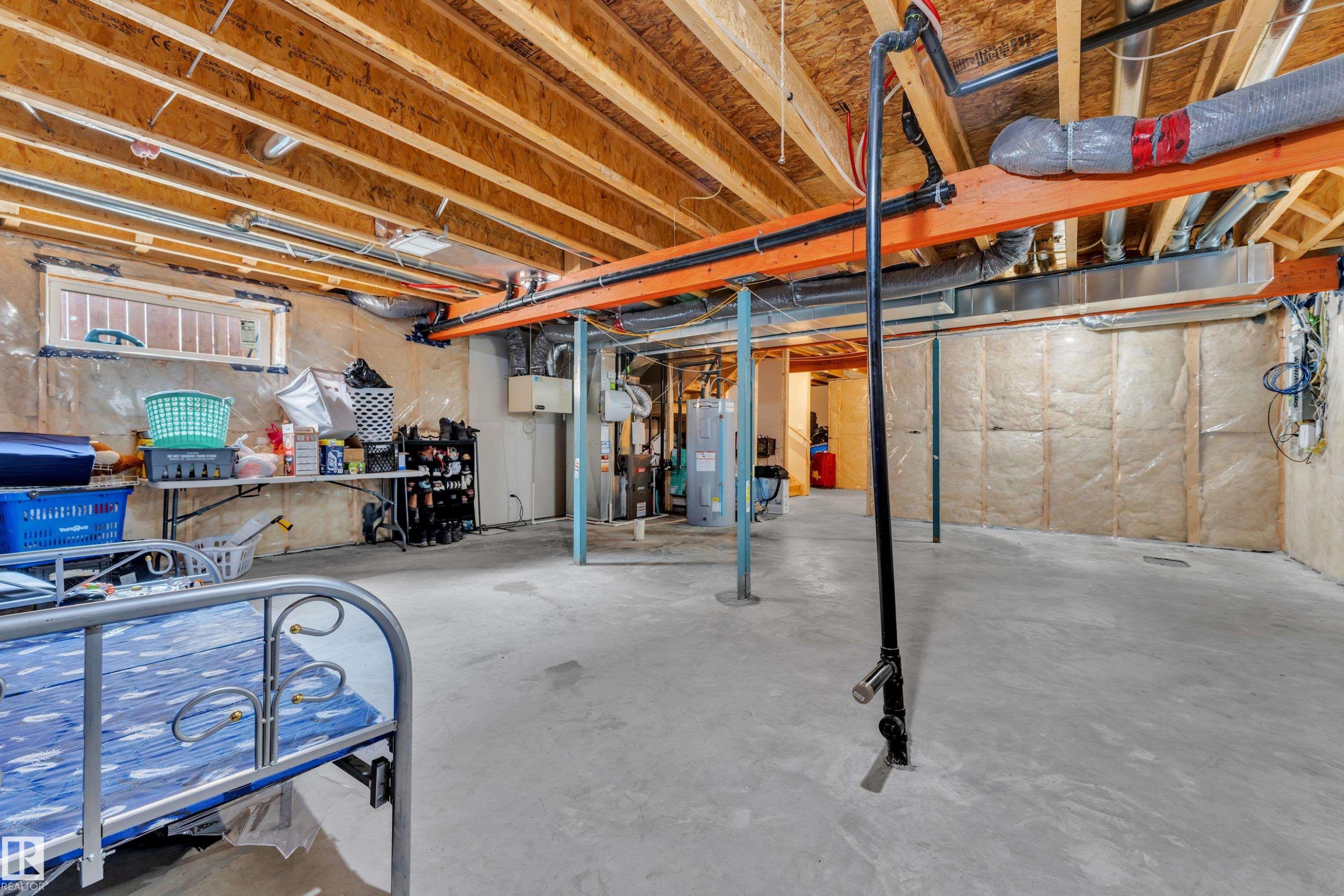 The property features an unfinished basement with exposed wooden joists and beams, concrete flooring, and insulated walls - 1452 30 Street, Edmonton, AB - Indoor Photo Showing Basement