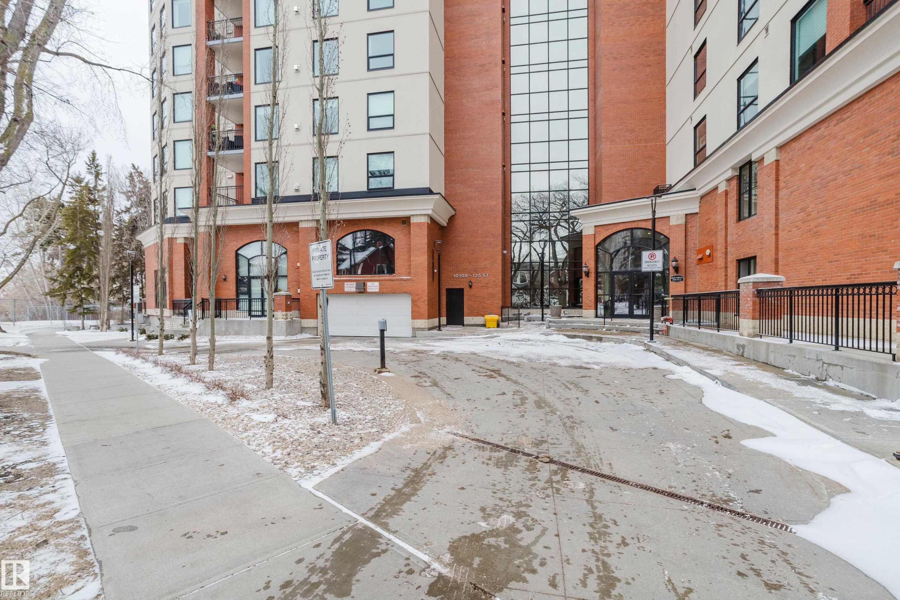 The property features an exterior with brick detailing, large arched windows, and a prominent glass facade - 206 10108 125 Street, Edmonton, AB - Outdoor