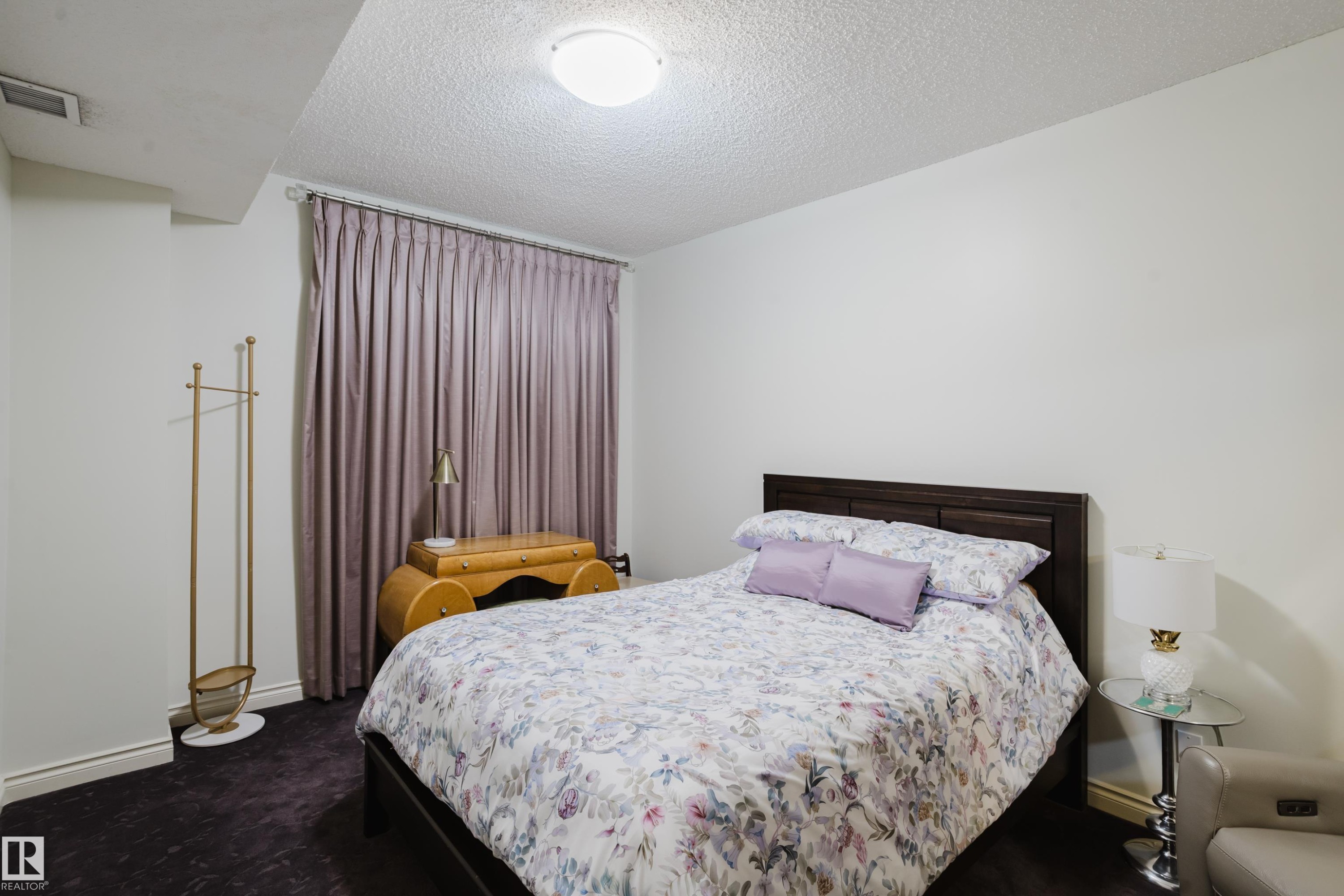 Bedroom with light-colored walls, dark flooring, and window treatments - 206 10108 125 Street, Edmonton, AB - Indoor Photo Showing Bedroom