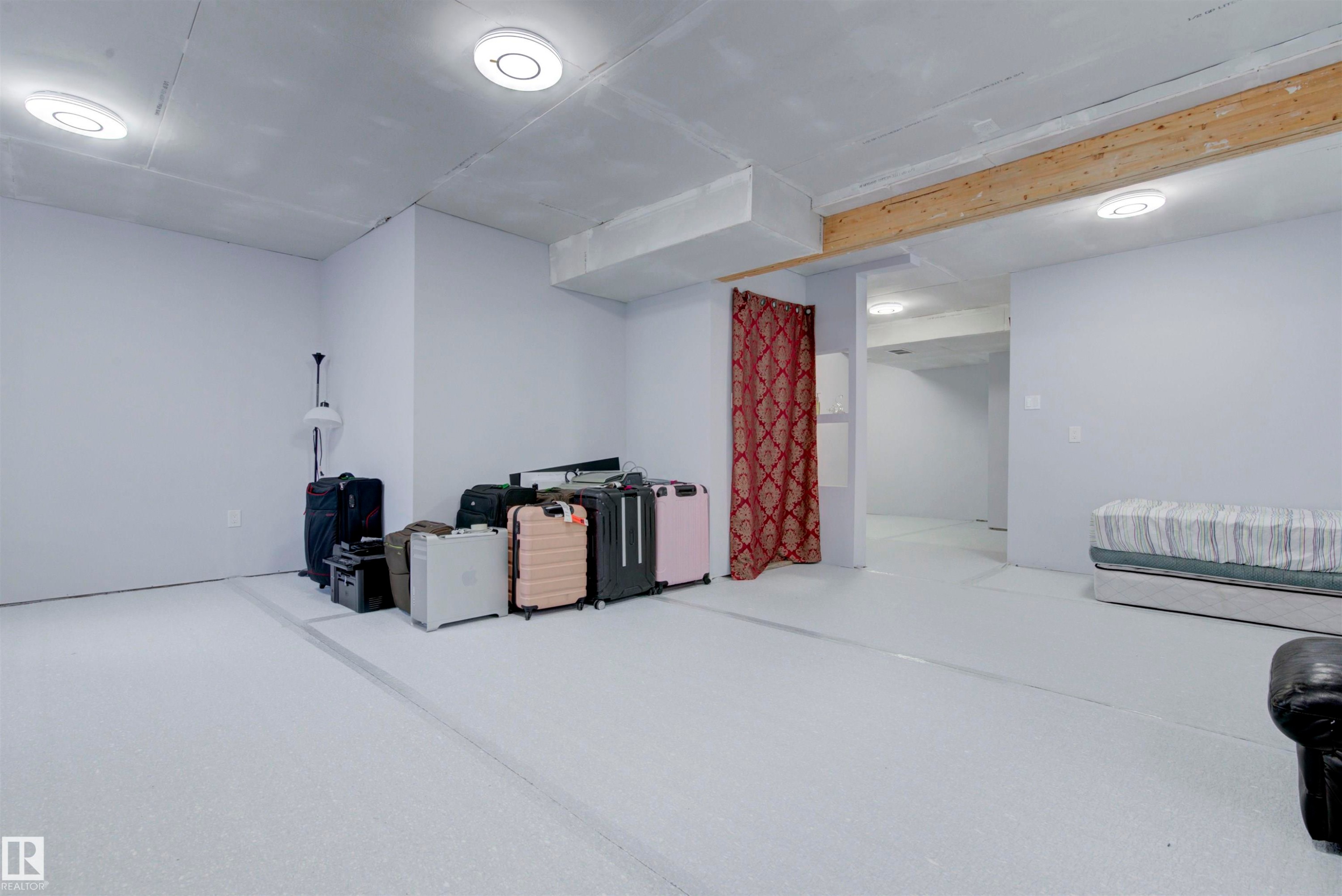 This spacious room features light-colored walls and flooring, with overhead lighting fixtures - 8452 Cushing Crest, Edmonton, AB - Indoor
