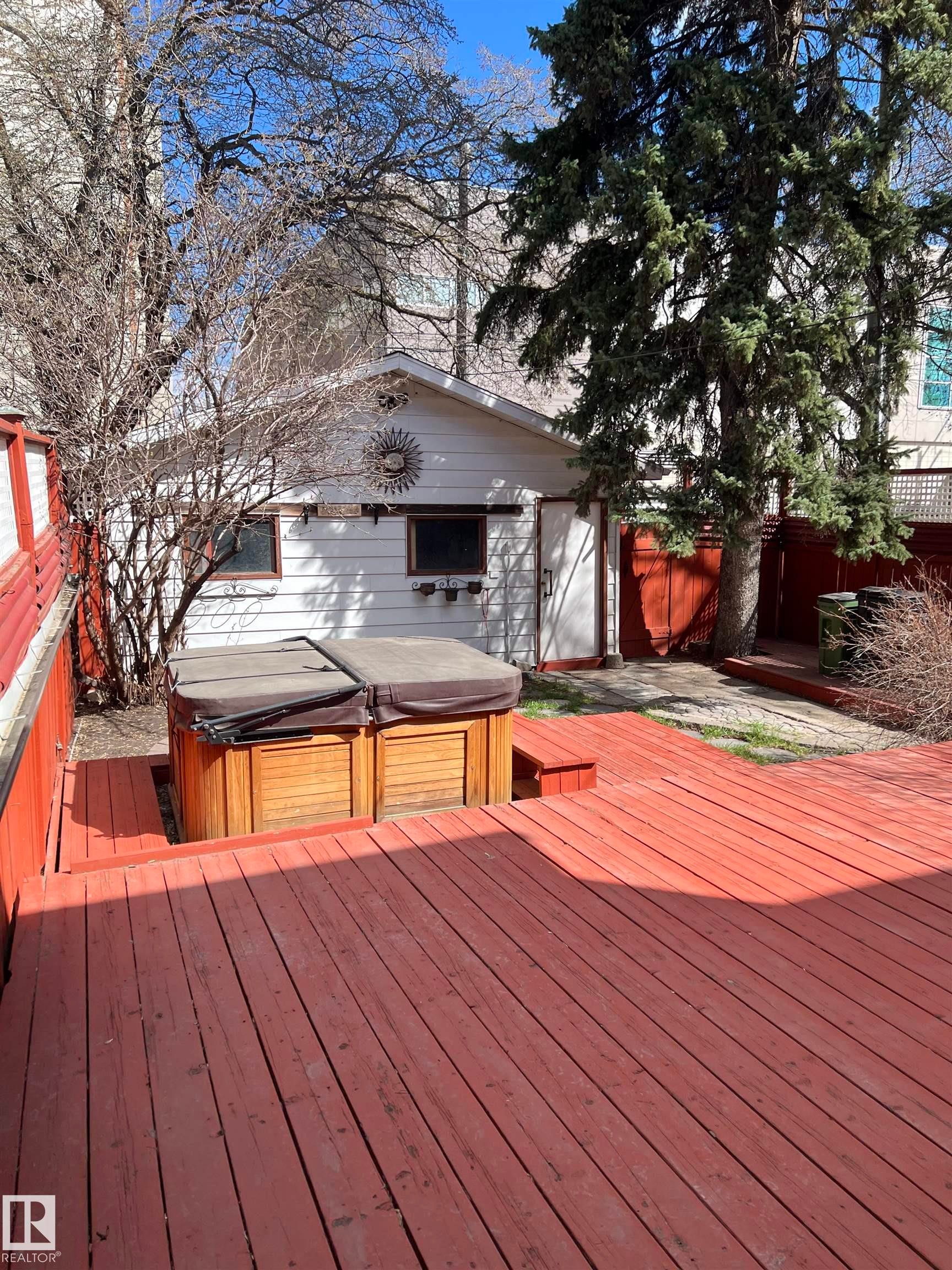 Expansive red-stained wood deck featuring a built-in hot tub - 10918 81 Avenue, Edmonton, AB - Outdoor