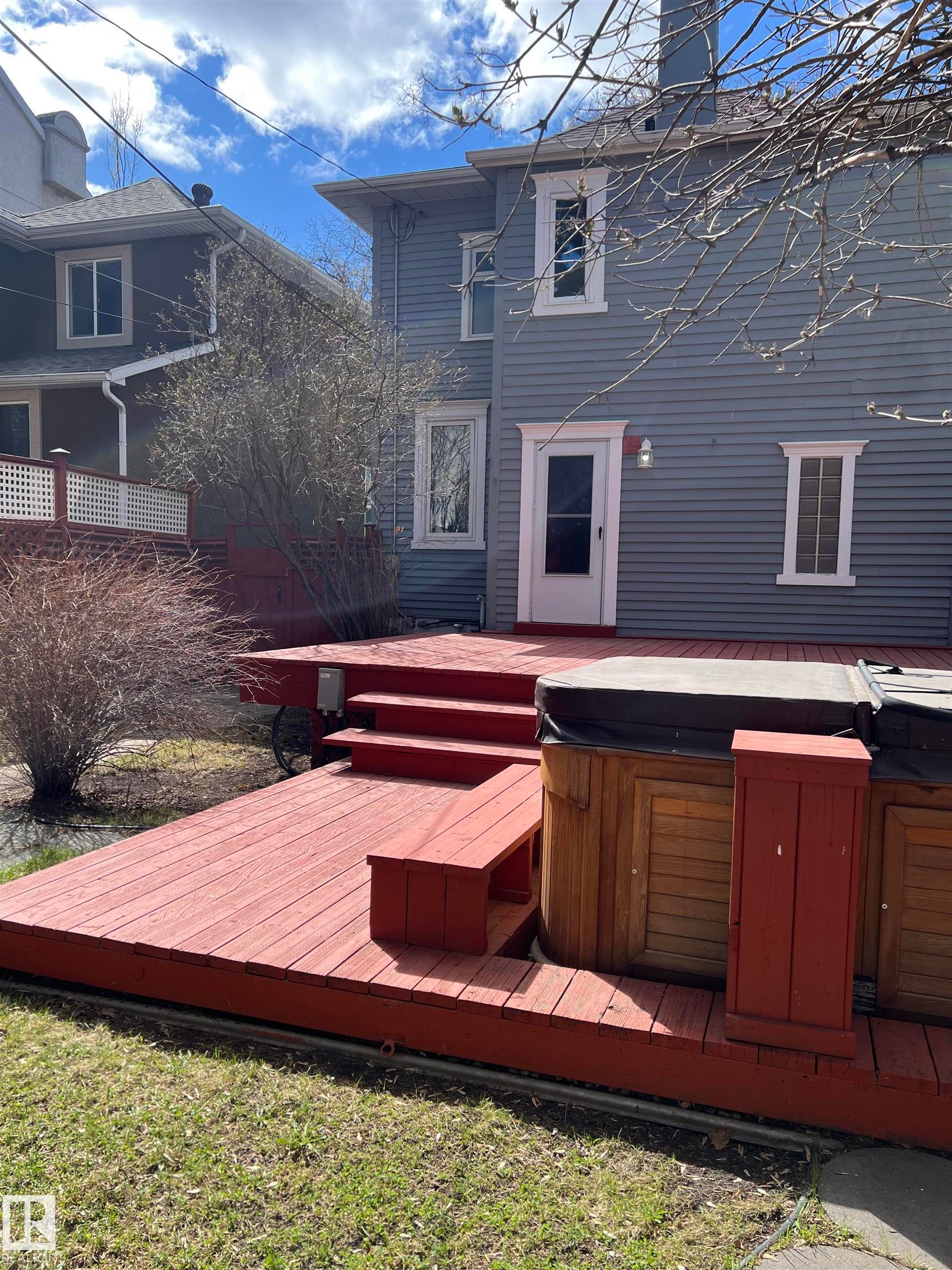 Spacious multi-level deck featuring a built-in bench, integrated hot tub, and direct access to the home - 10918 81 Avenue, Edmonton, AB - Outdoor