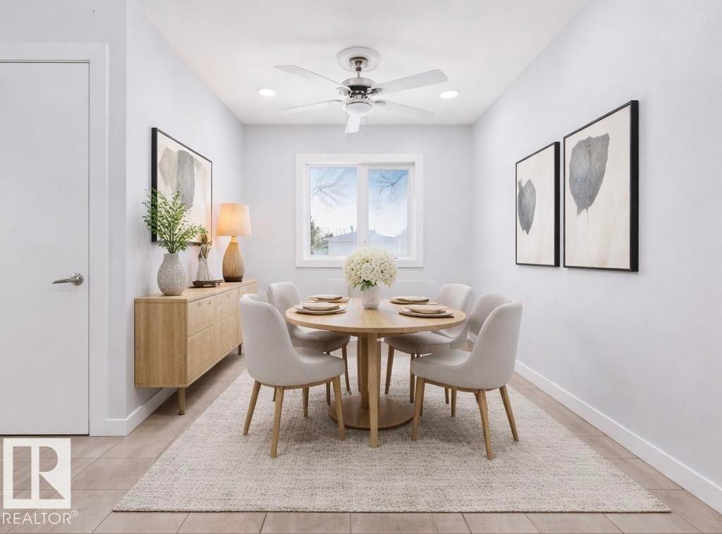 This inviting dining space features light-colored walls, a ceiling fan, and a window providing natural light - 12002 37 Street, Edmonton, AB - Indoor Photo Showing Dining Room