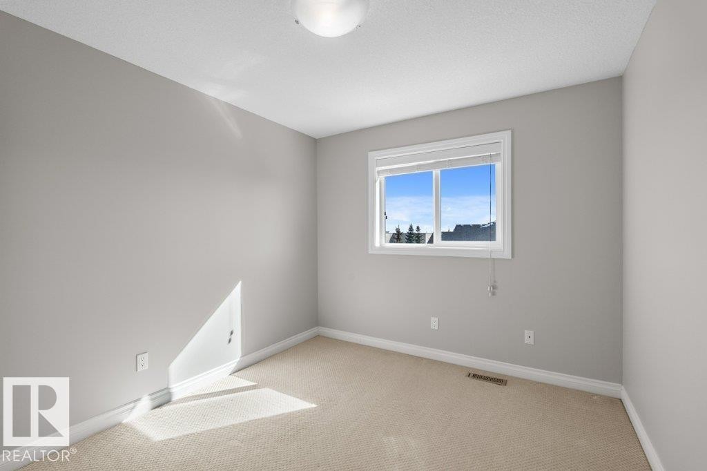 This room features light grey walls, white trim, and neutral-toned carpet - 16419 53 Street, Edmonton, AB - Indoor Photo Showing Other Room