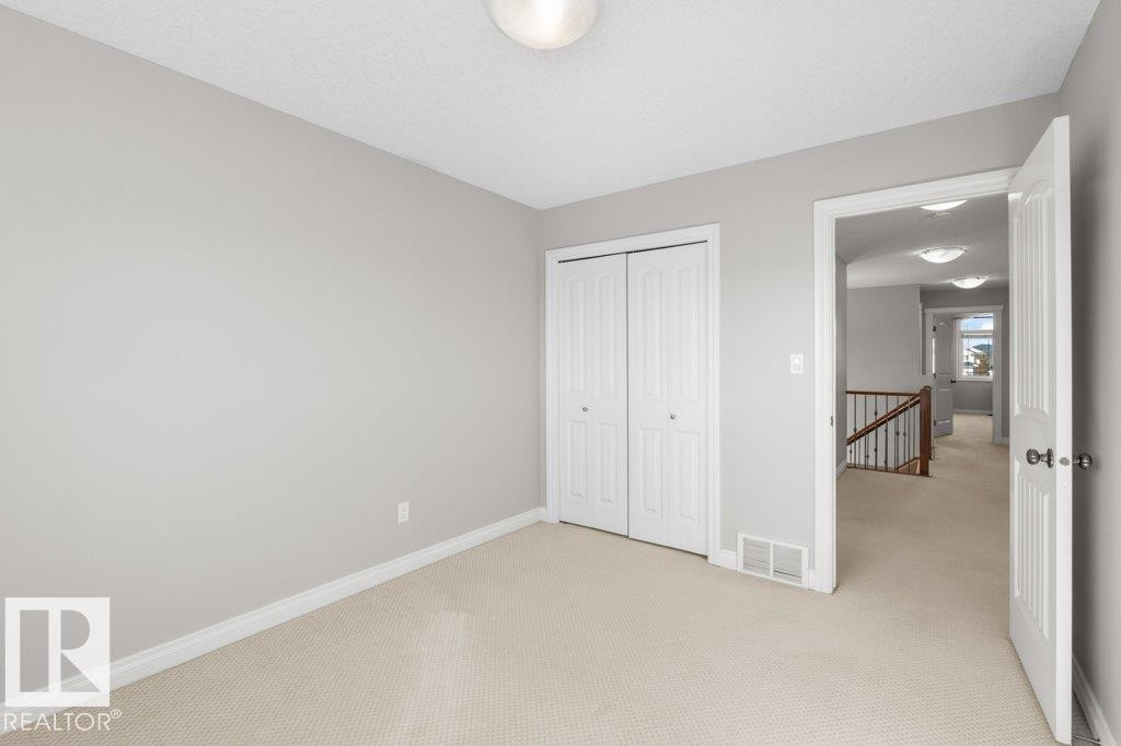 This room features light grey walls and light-colored carpet flooring - 16419 53 Street, Edmonton, AB - Indoor Photo Showing Other Room