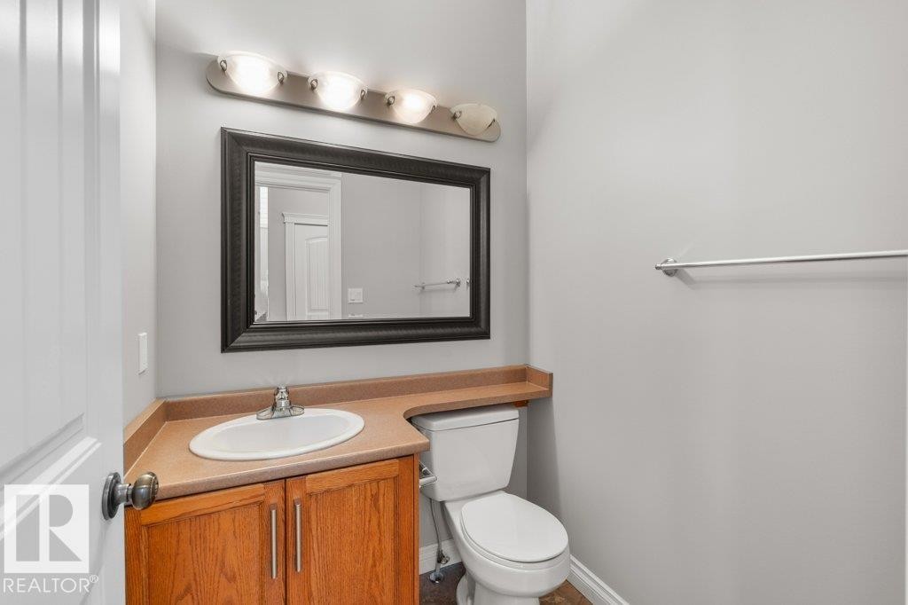 Well-appointed bathroom featuring a vanity with wood cabinetry, a mirror with a dark frame, and overhead lighting - 16419 53 Street, Edmonton, AB - Indoor Photo Showing Bathroom