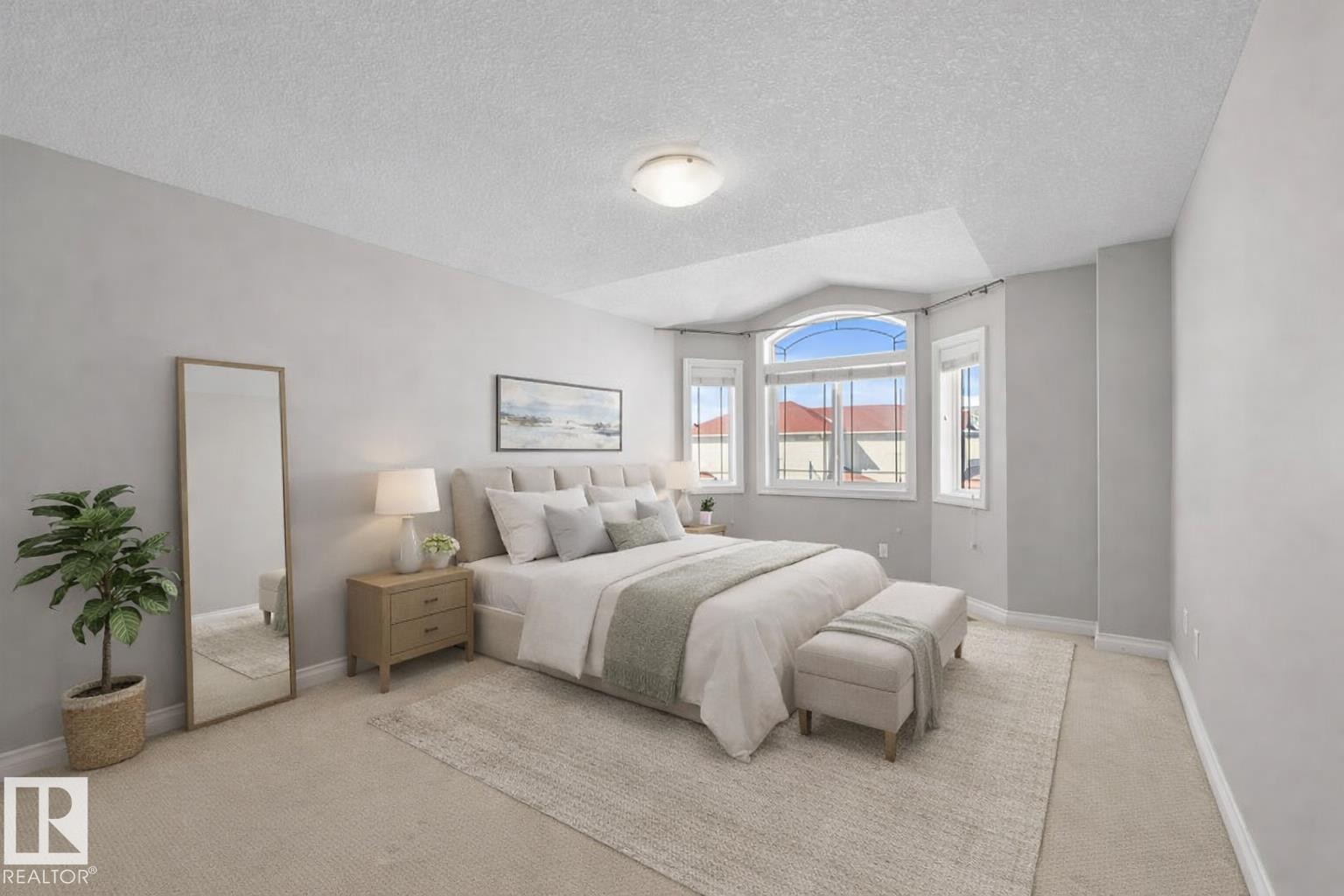 Bright bedroom featuring a large bay window, carpeted flooring, and light-colored walls - 16419 53 Street, Edmonton, AB - Indoor Photo Showing Bedroom