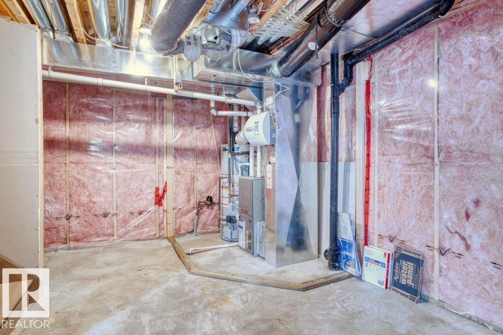 Unfinished basement area with exposed insulation, concrete flooring, and visible ductwork - 16419 53 Street, Edmonton, AB - Indoor Photo Showing Basement