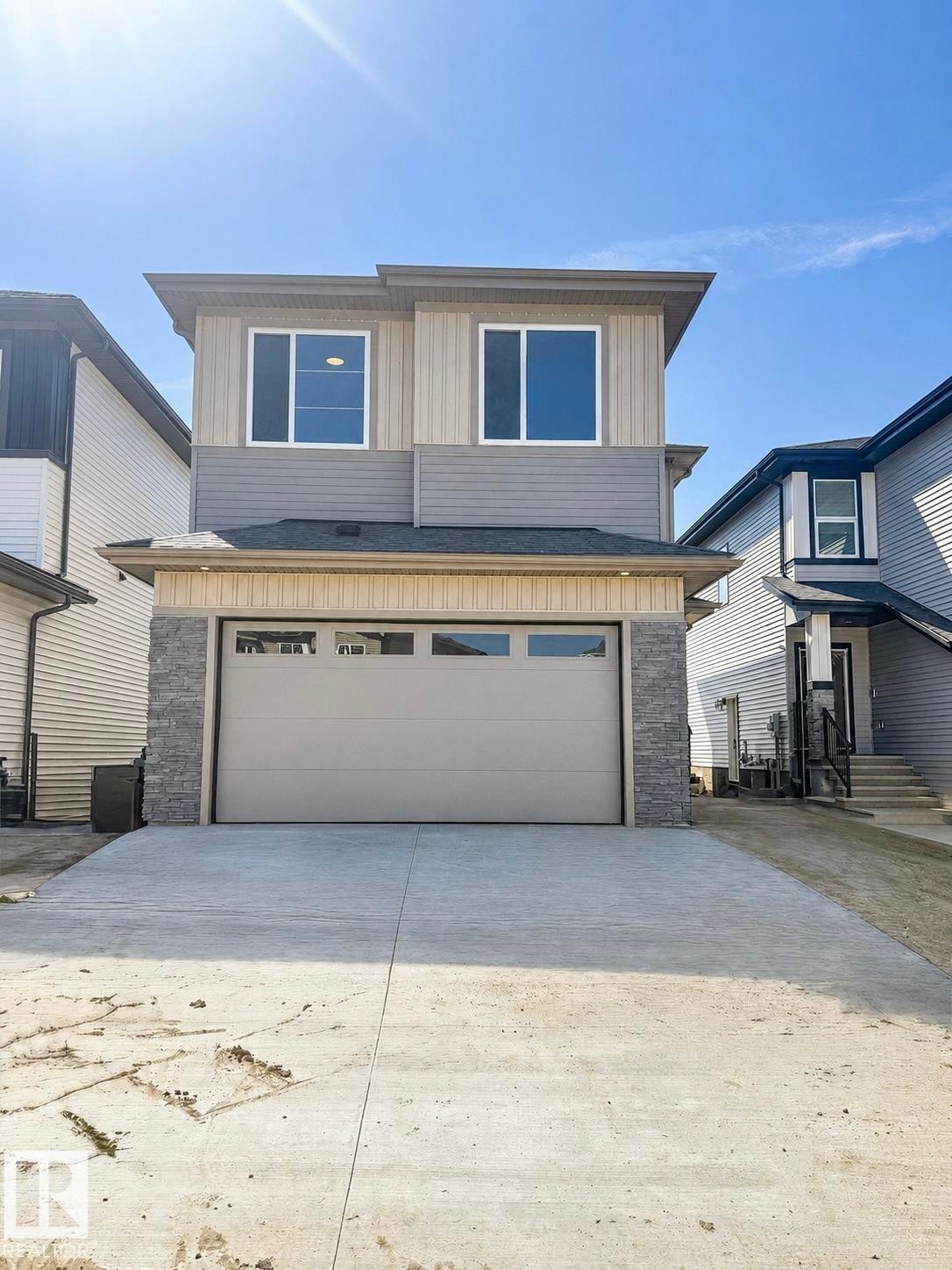 Two-story exterior with multi-toned siding, stone veneer accents, and a single garage - 22 Meadowgrove Landing, Spruce Grove, AB - Outdoor