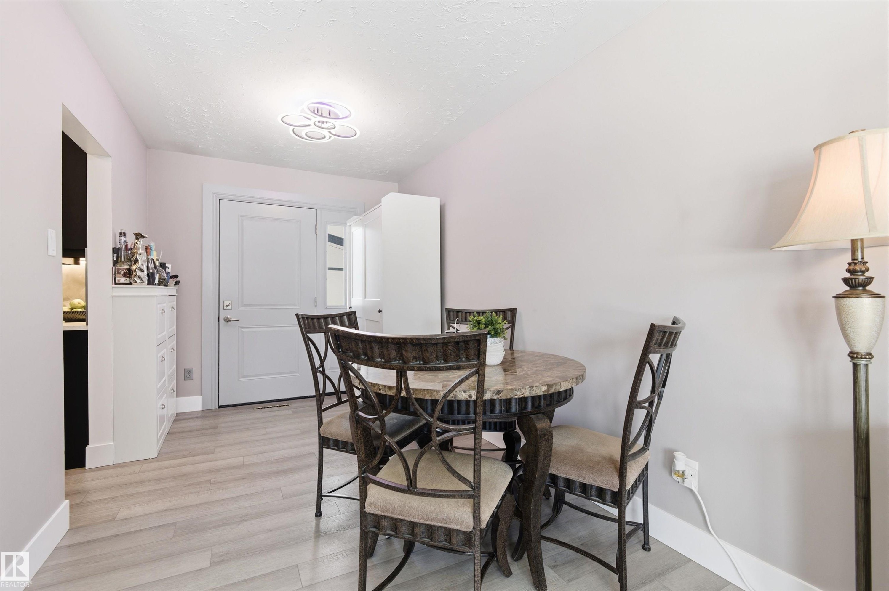 The property features light-colored walls, light-toned flooring, and a modern ceiling light fixture - 12904 95 Street, Edmonton, AB - Indoor Photo Showing Dining Room