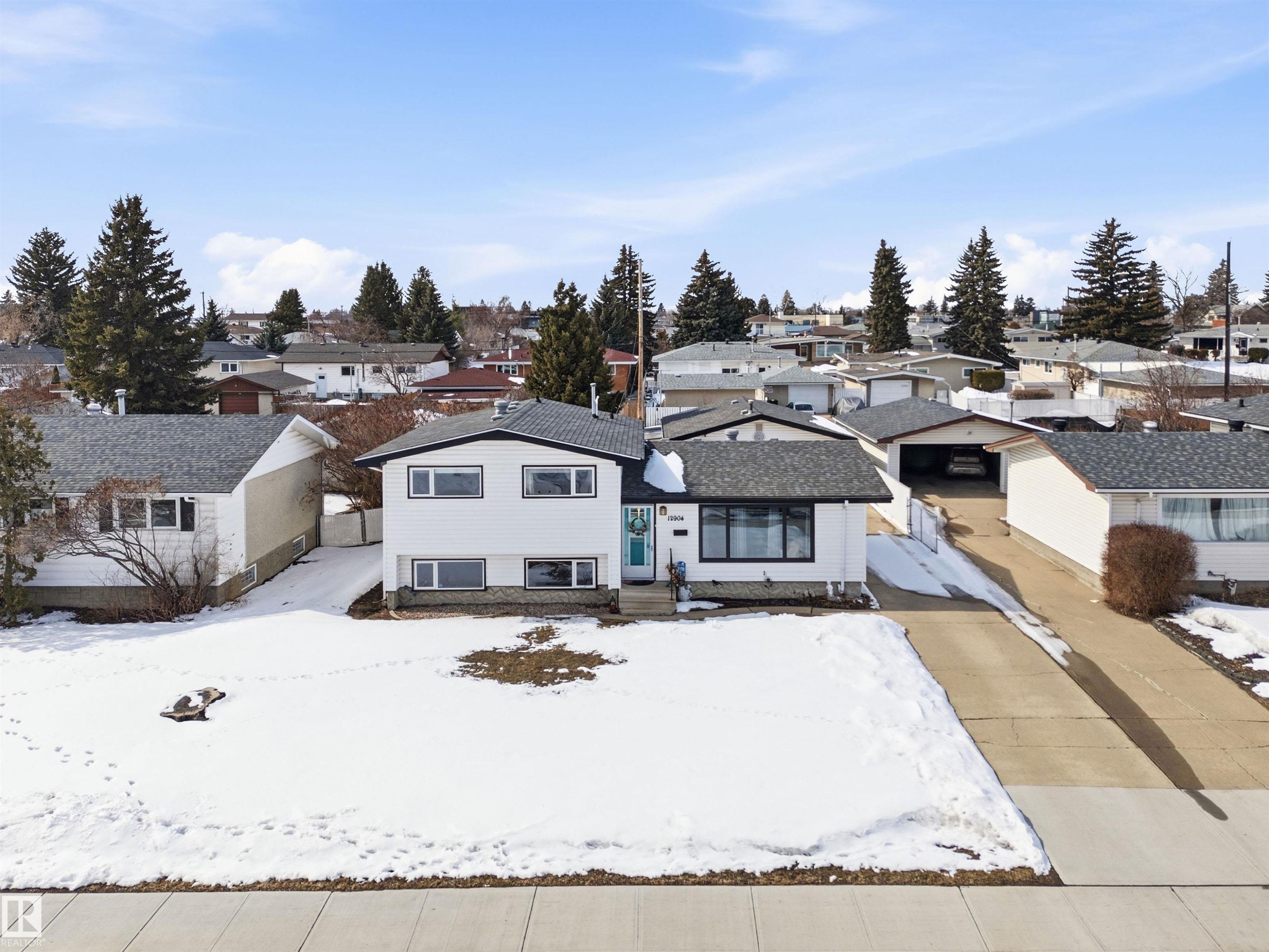 The property features a white exterior with black trim, a dark grey shingled roof, and an attached driveway - 12904 95 Street, Edmonton, AB - Outdoor With Facade