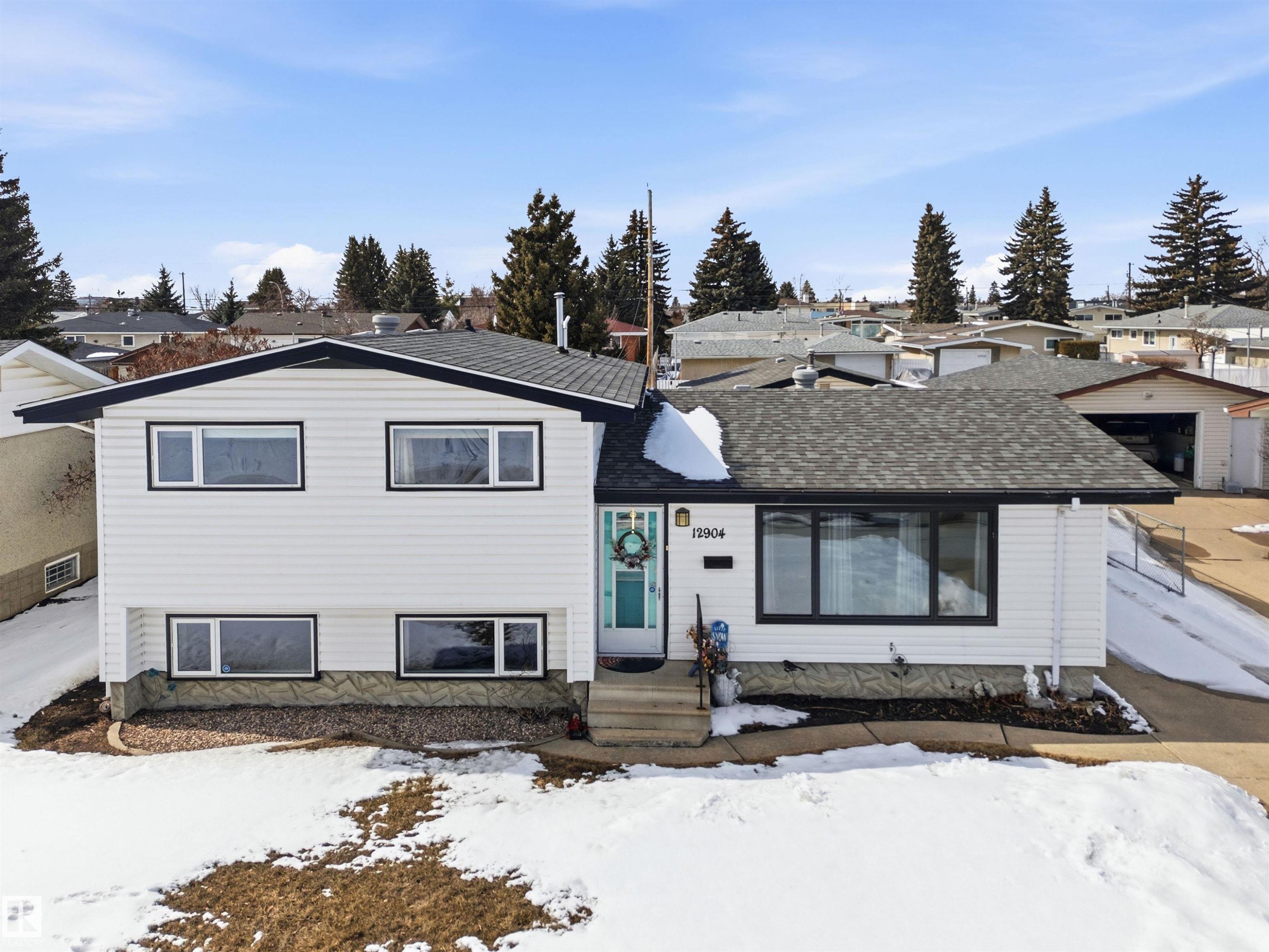 The property features a white exterior with black trim, a dark shingle roof, and a turquoise front door - 12904 95 Street, Edmonton, AB - Outdoor