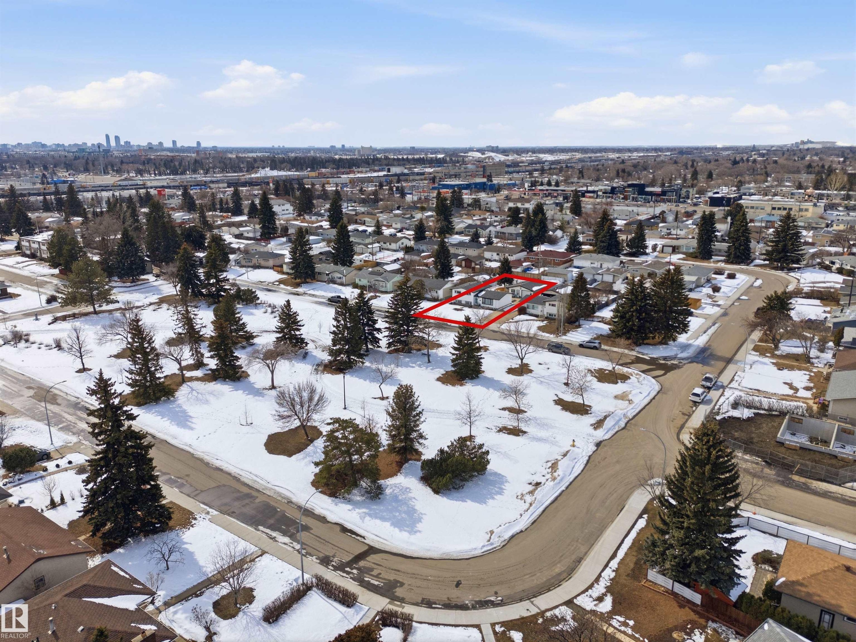 Aerial view showcasing the property situated within a neighborhood featuring mature trees and a distant cityscape - 12904 95 Street, Edmonton, AB - Outdoor With View