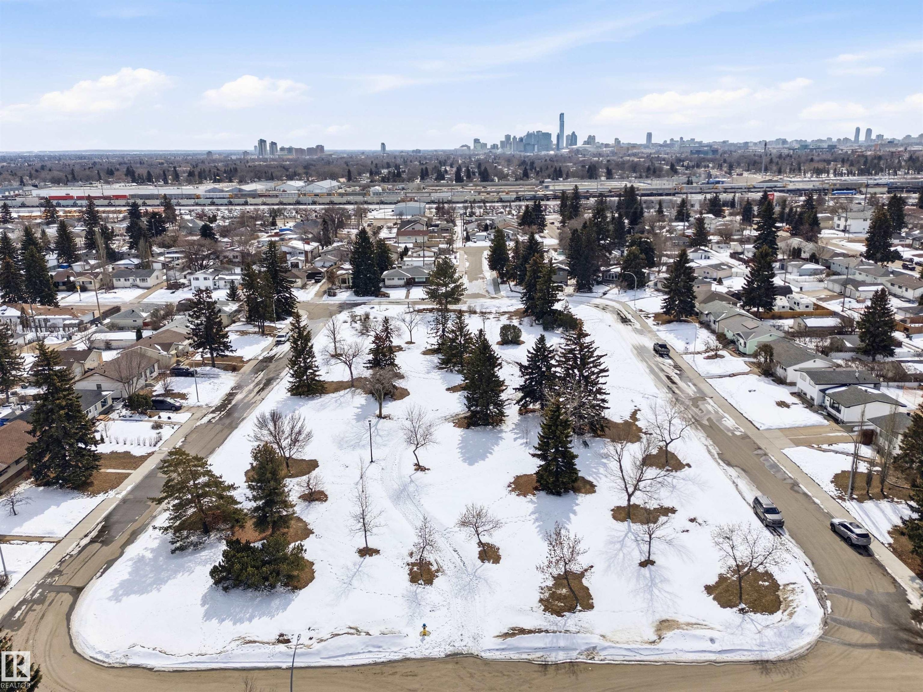 Aerial view showcasing a residential area with a prominent park space, surrounded by streets and houses - 12904 95 Street, Edmonton, AB - Outdoor With View