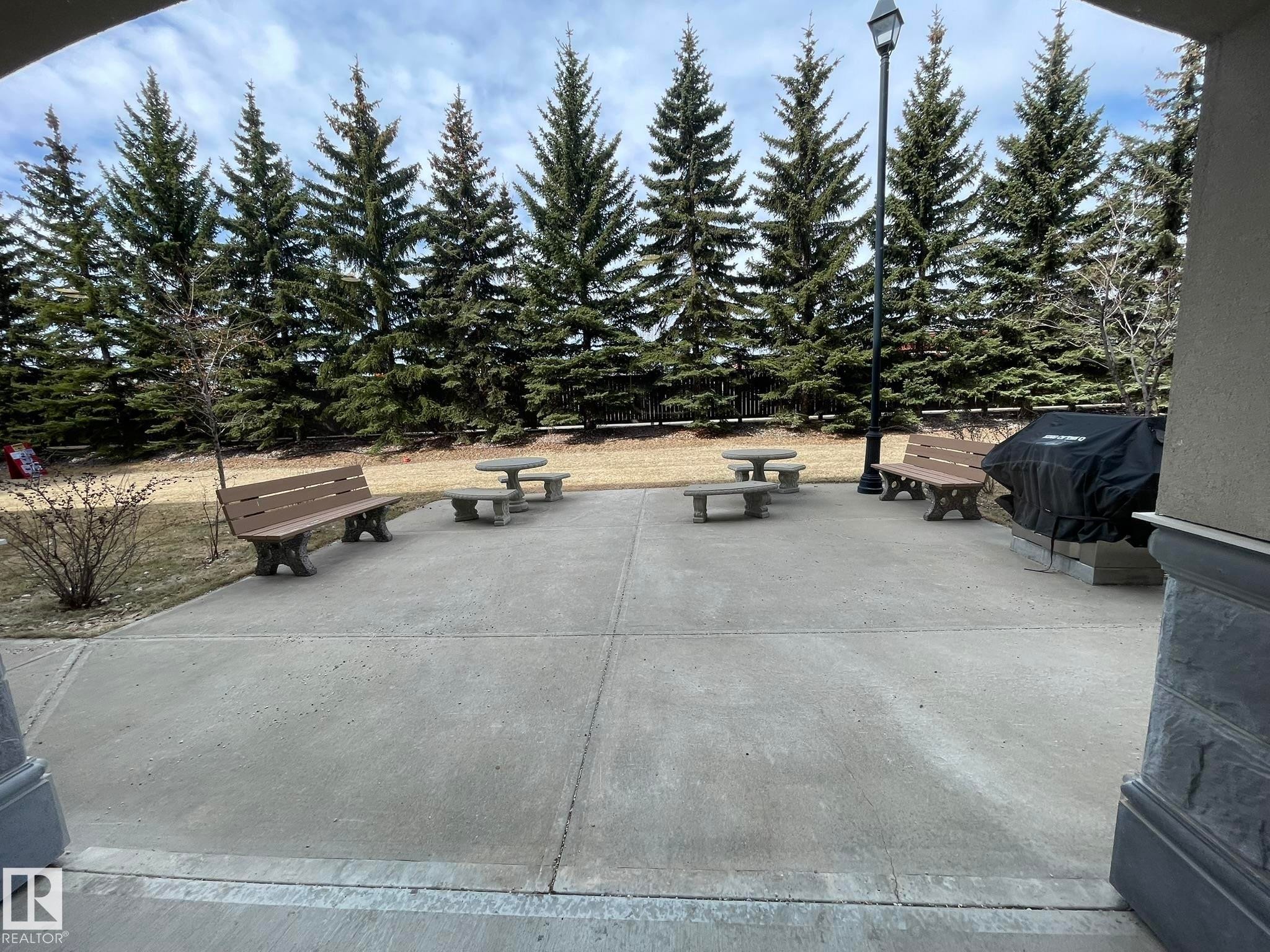The property features a spacious paved patio area with benches and picnic tables, ideal for outdoor enjoyment - Edmonton, AB - Outdoor