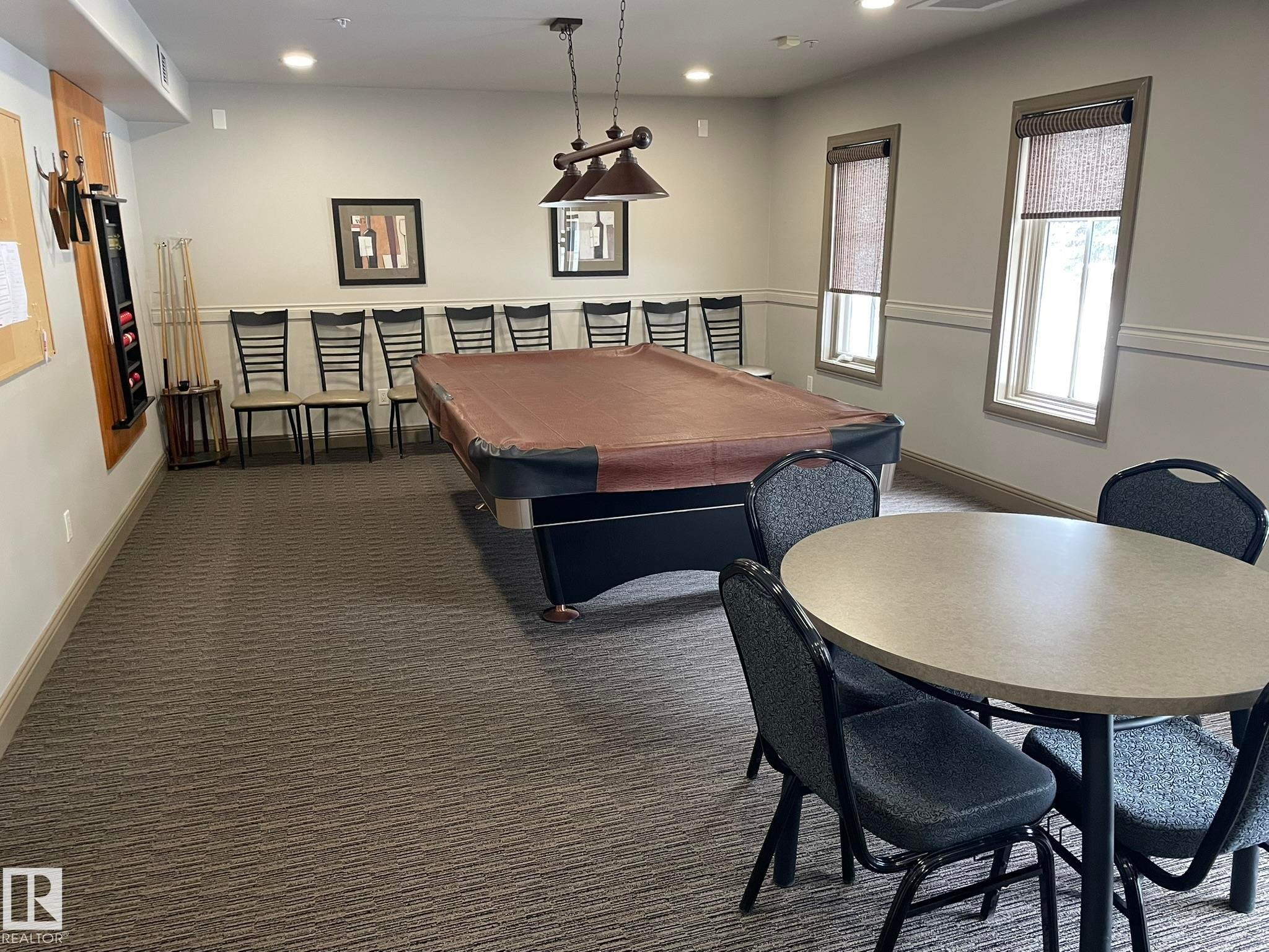 This property features a recreation room with a pool table, overhead lighting, and two windows - Edmonton, AB - Indoor