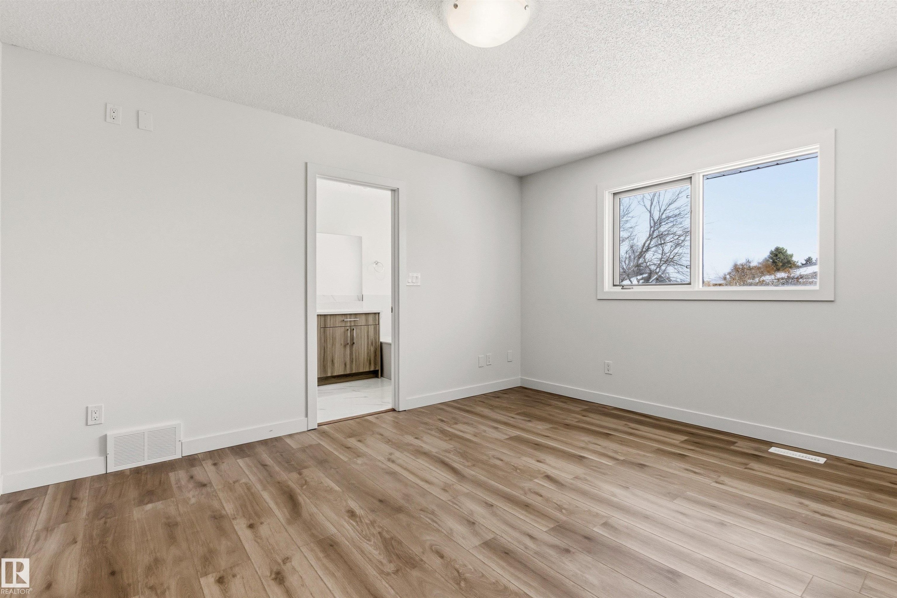 The room features light-toned walls, wood-look flooring, and a window providing views of the outdoors - 3668 31A Street, Edmonton, AB - Indoor Photo Showing Other Room