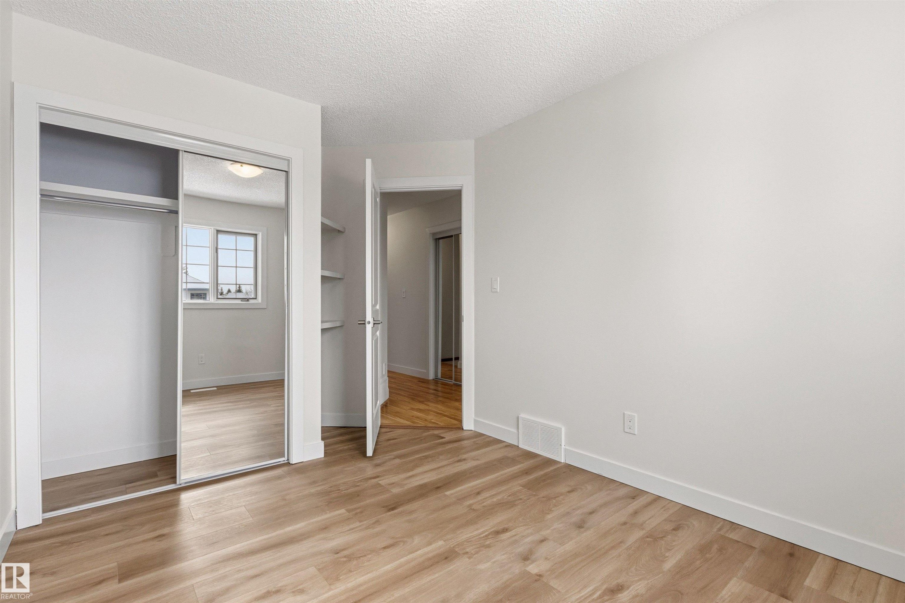 This room features light wood-style flooring and white walls, offering a bright and versatile space - 3668 31A Street, Edmonton, AB - Indoor Photo Showing Other Room