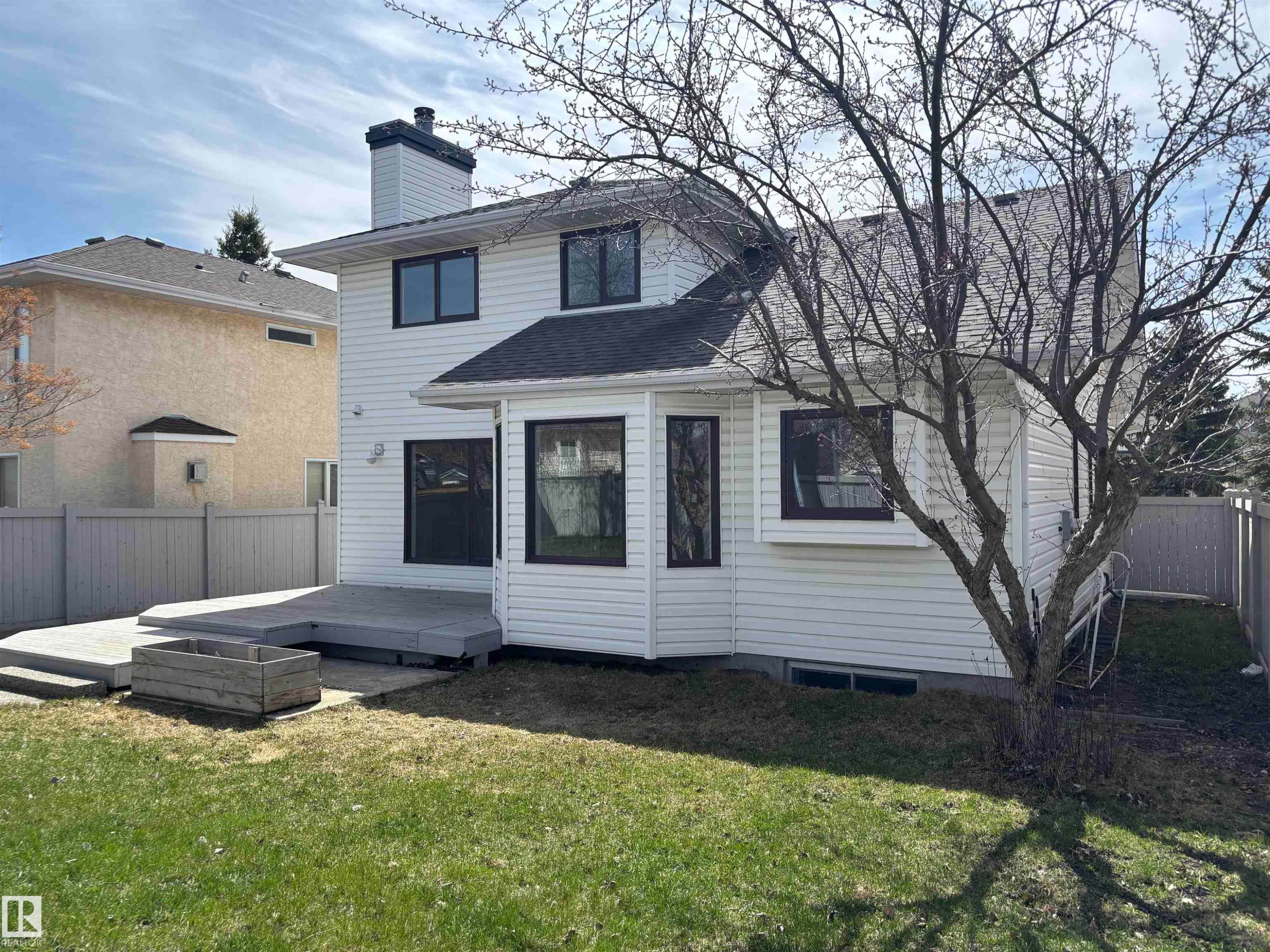 Rear exterior featuring a multi-level deck, white siding, and a fenced yard - 3668 31A Street, Edmonton, AB - Outdoor