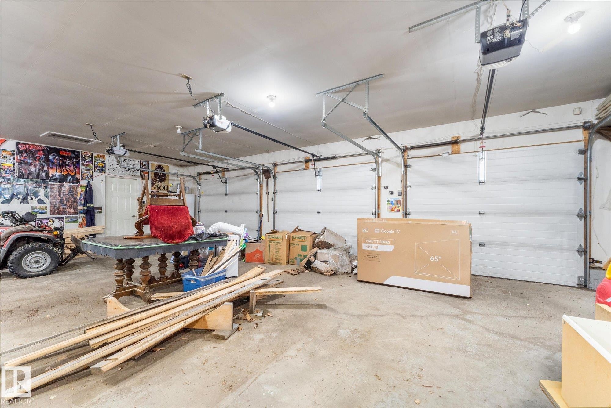 Spacious two-car garage with concrete flooring and multiple overhead light fixtures - 25750 18 Street, Edmonton, AB - Indoor Photo Showing Garage