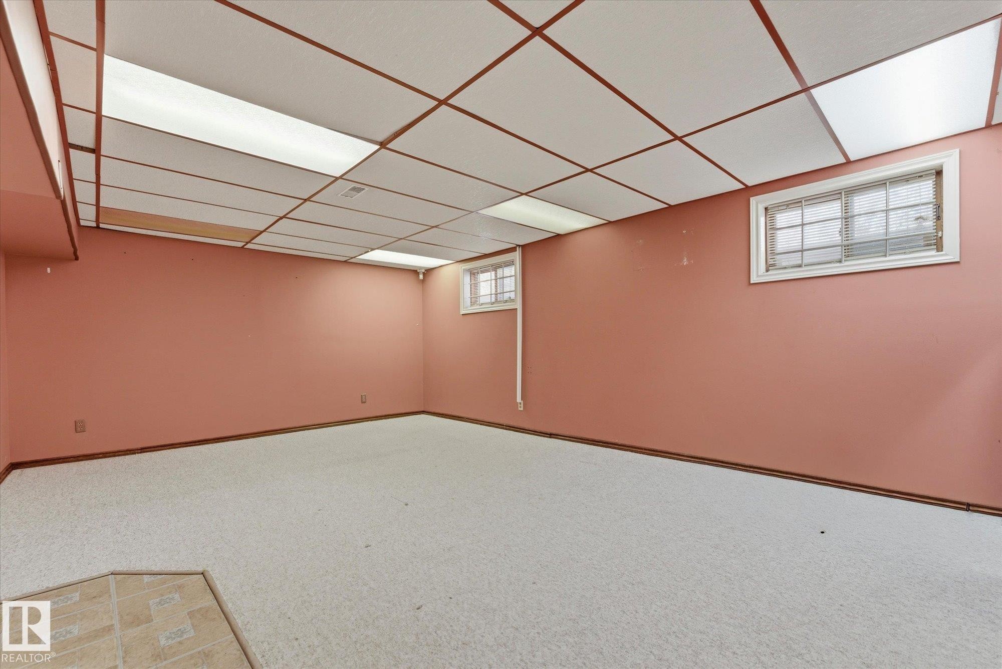 Spacious room featuring light-colored carpet, a drop ceiling with integrated lighting, and two windows - 25750 18 Street, Edmonton, AB - Indoor Photo Showing Other Room