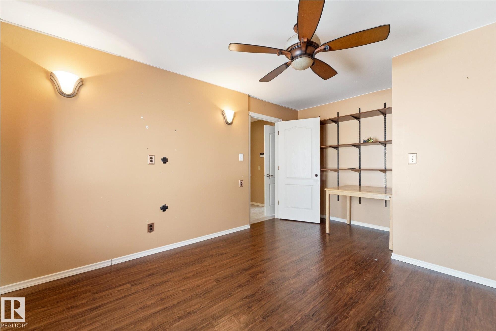 Wood-finish flooring throughout, complemented by a ceiling fan with integrated lighting - 25750 18 Street, Edmonton, AB - Indoor Photo Showing Other Room