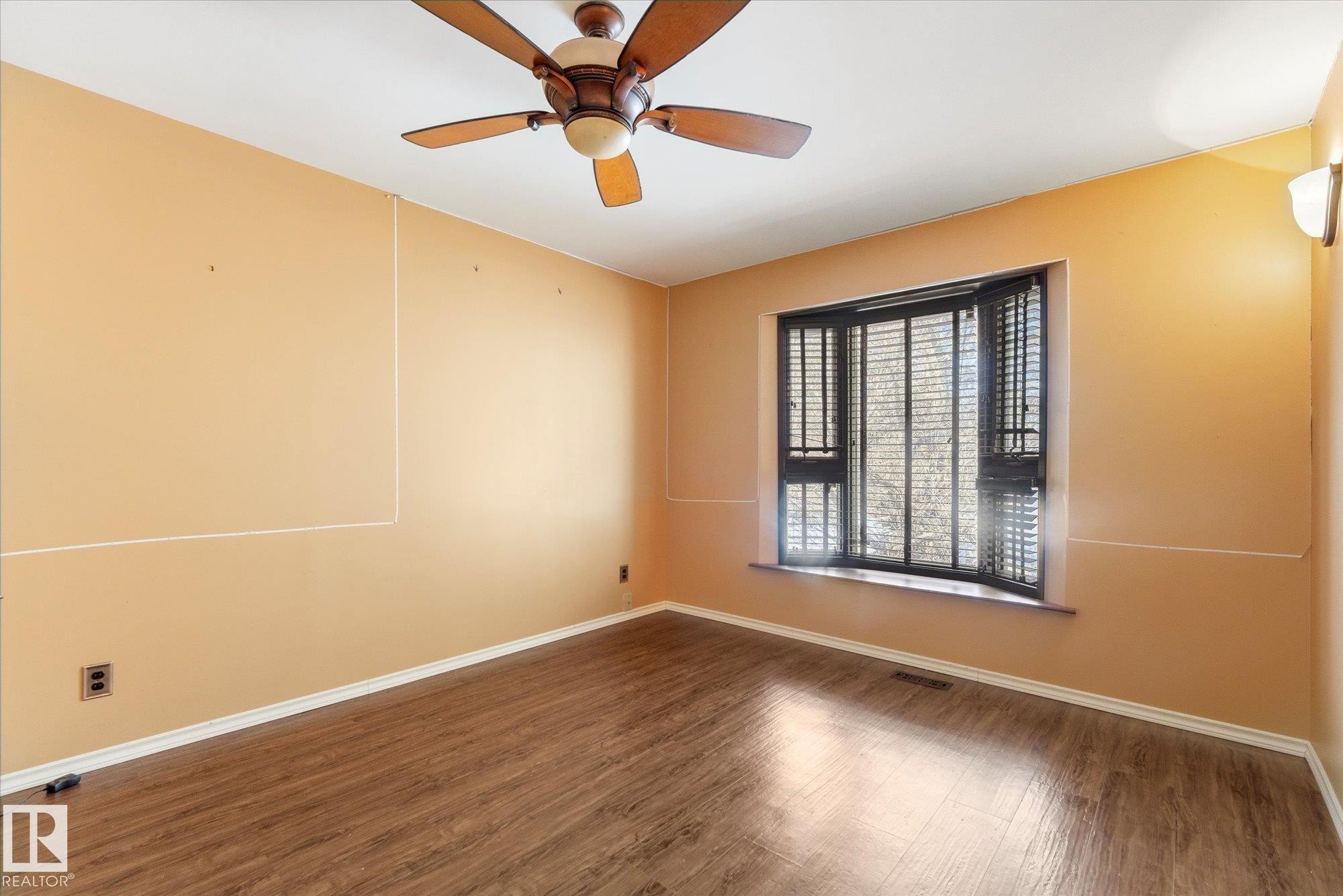 Room featuring wood-finish flooring, a ceiling fan, bay window with blinds, and wall sconce lighting - 25750 18 Street, Edmonton, AB - Indoor Photo Showing Other Room