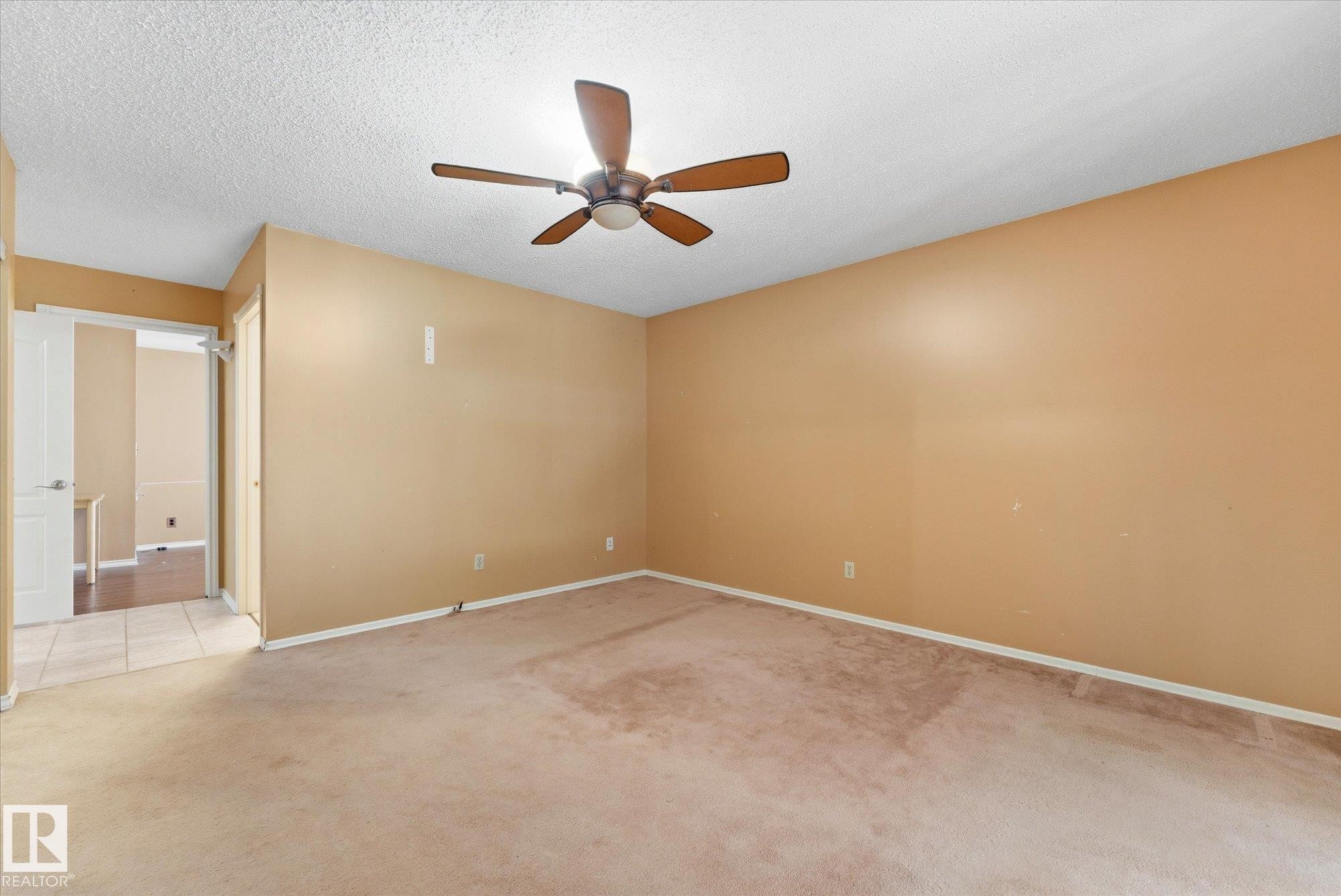 Spacious room featuring neutral-toned walls, a textured ceiling, and a ceiling fan with wood-finish blades - 25750 18 Street, Edmonton, AB - Indoor Photo Showing Other Room