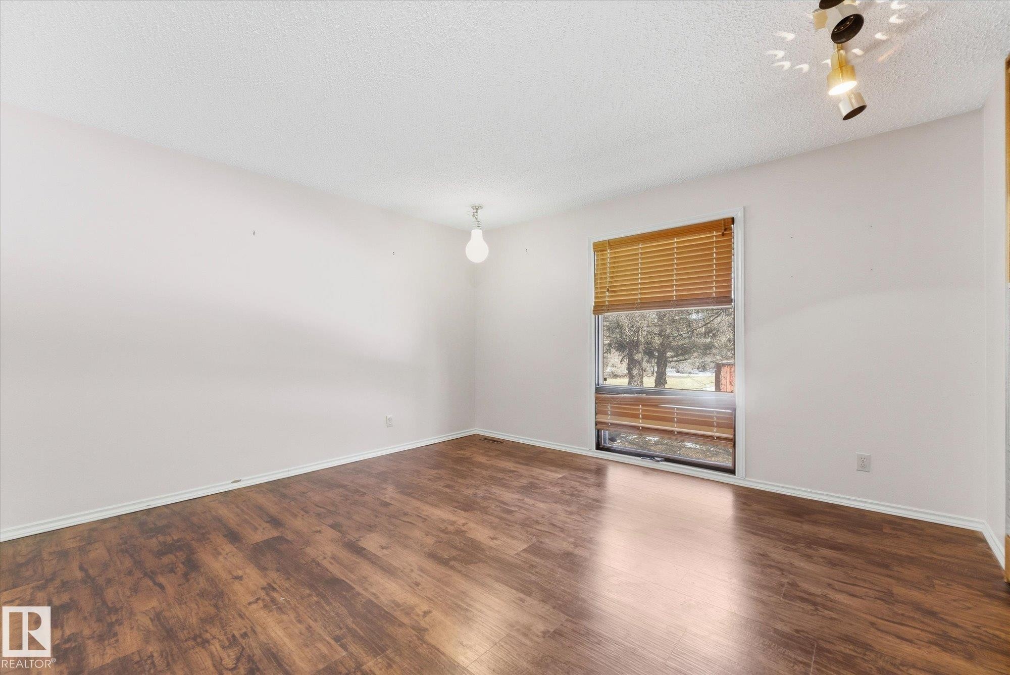 Room featuring wood-finish flooring, white walls, and a window with wood blinds - 25750 18 Street, Edmonton, AB - Indoor Photo Showing Other Room