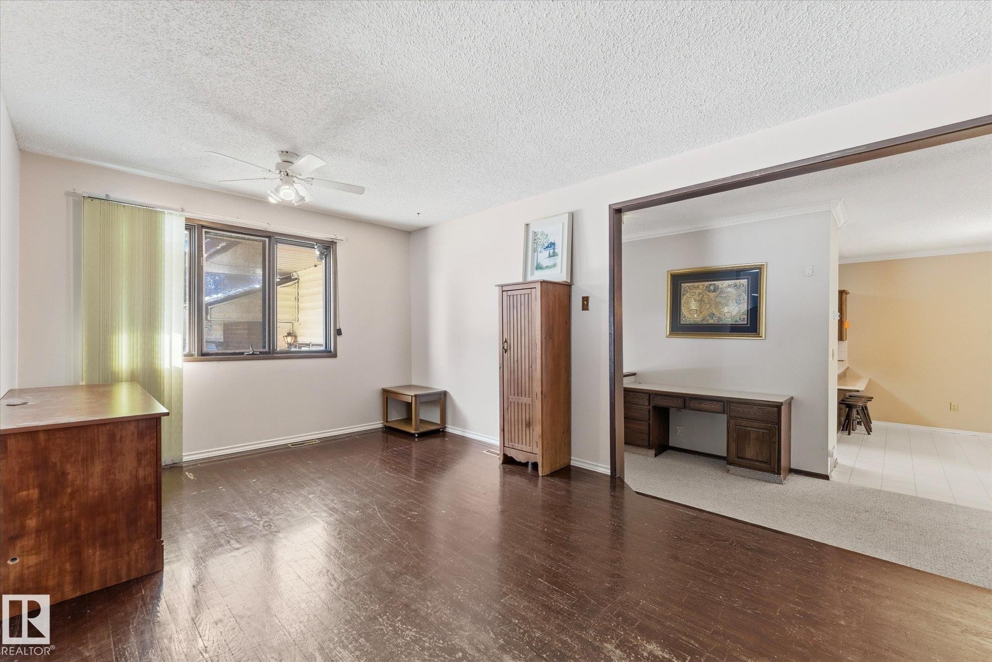 Room featuring dark wood-finish flooring, a window with vertical blinds, and a ceiling fan - 25750 18 Street, Edmonton, AB - Indoor