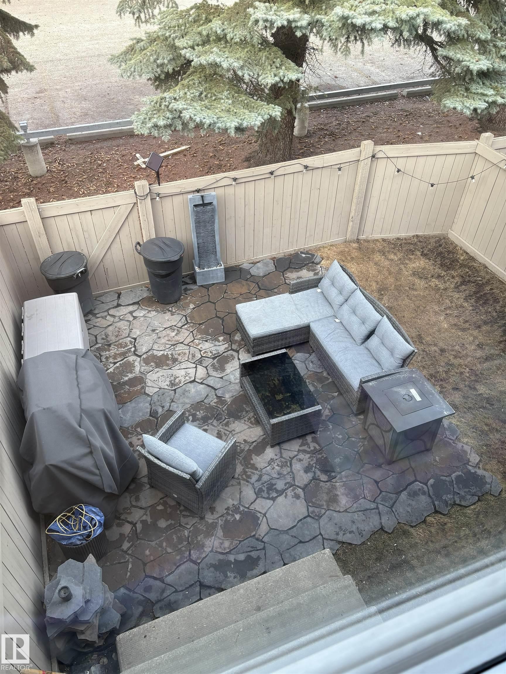 Private patio area featuring a flagstone-style hardscape and a wood privacy fence - 79 Akinsdale Gardens, St. Albert, AB - Outdoor