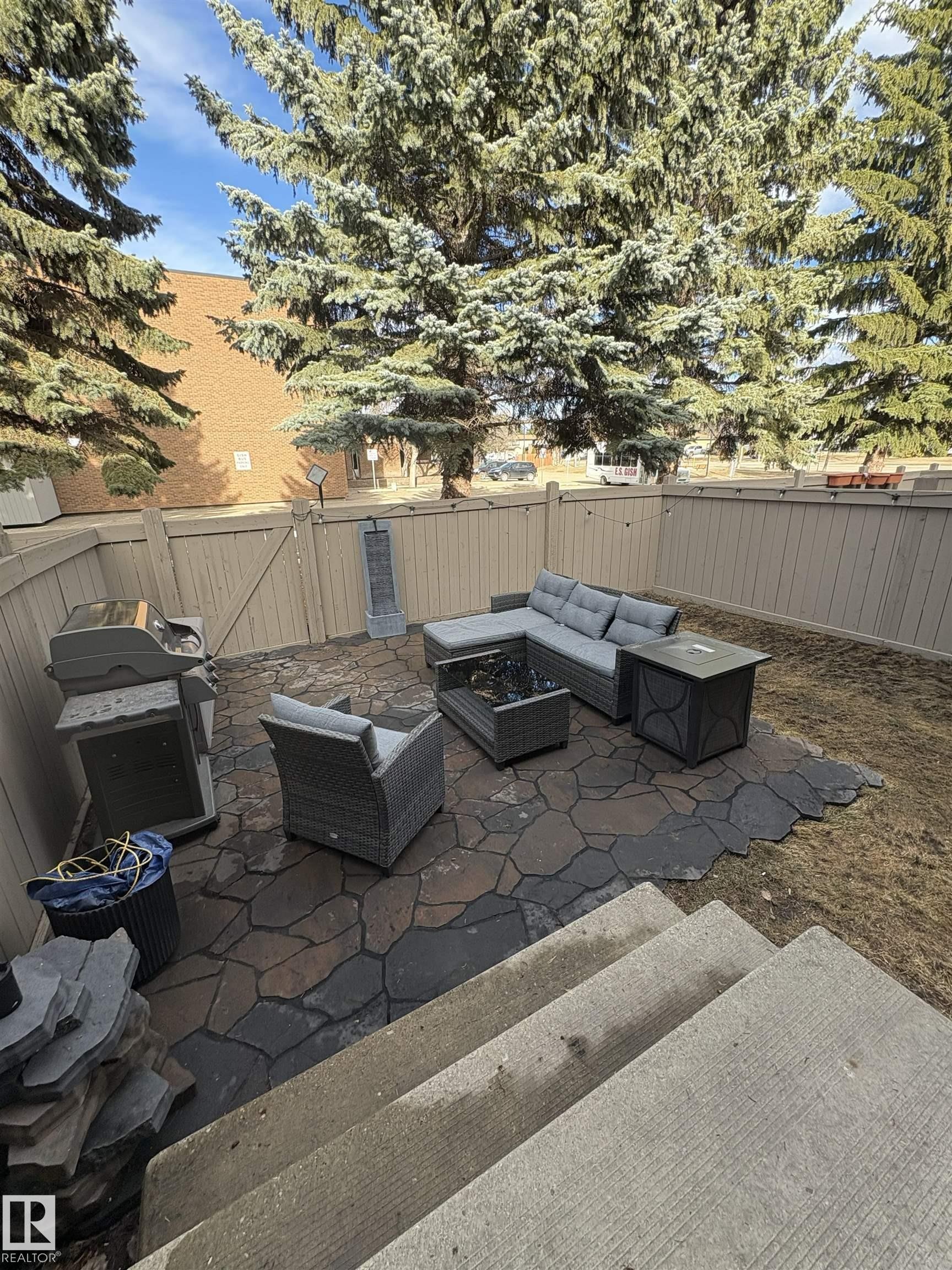 Private backyard patio featuring multi-toned flagstone pavers and a perimeter fence - 79 Akinsdale Gardens, St. Albert, AB - Outdoor