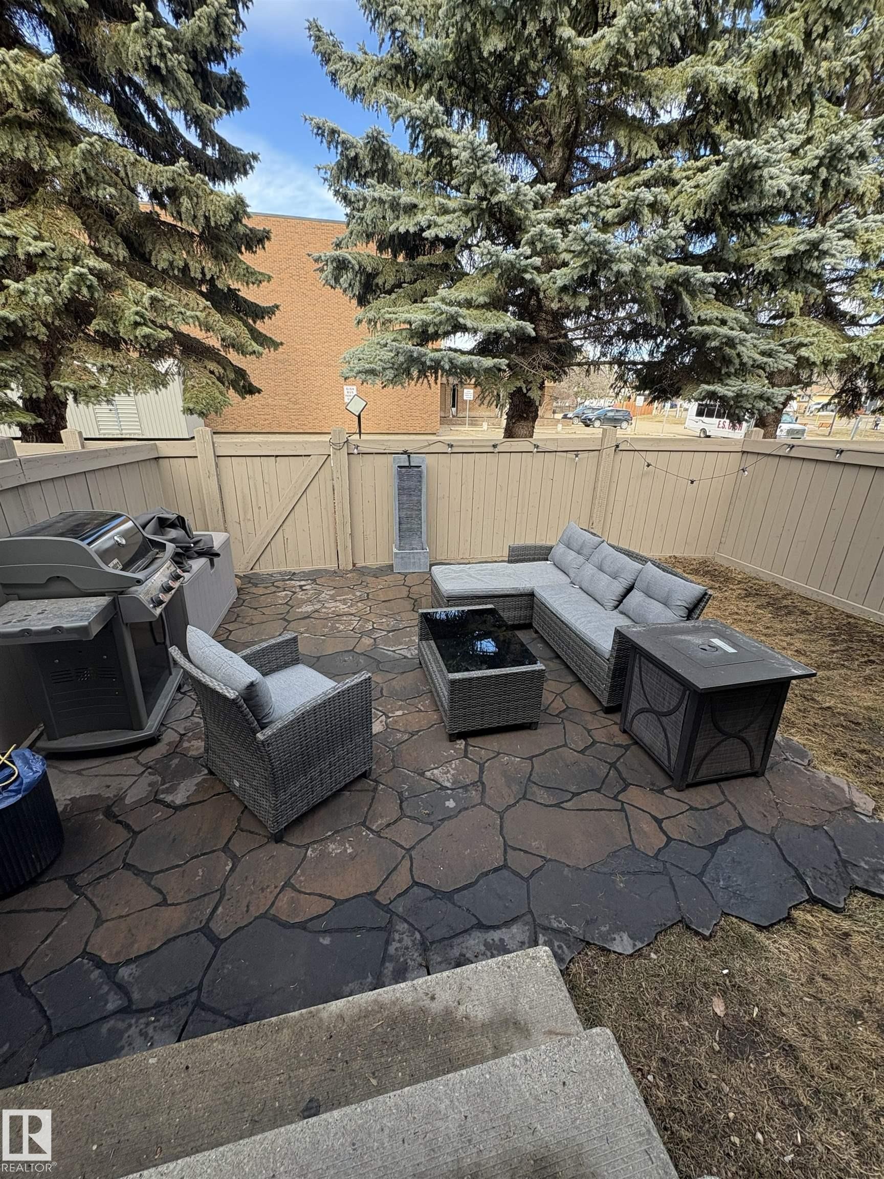 Expansive flagstone patio featuring a natural stone surface and perimeter fencing - 79 Akinsdale Gardens, St. Albert, AB - Outdoor With Deck Patio Veranda