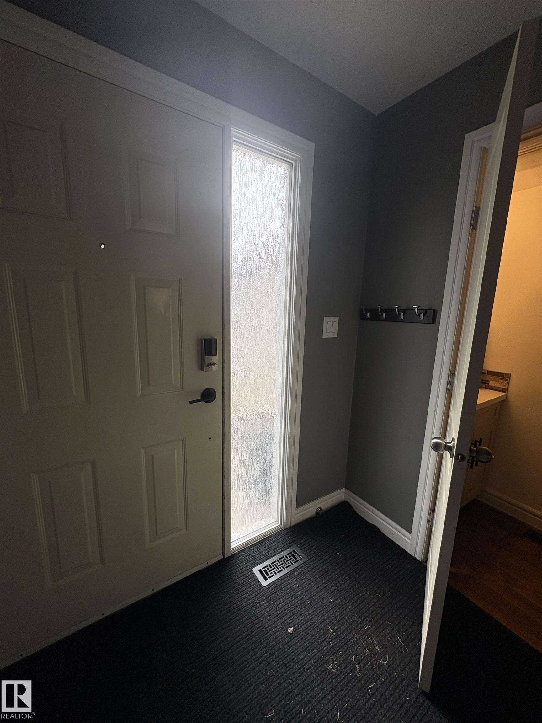 Entryway featuring a paneled door with matte black hardware, frosted sidelight, and dark textured flooring - 79 Akinsdale Gardens, St. Albert, AB - Indoor Photo Showing Other Room