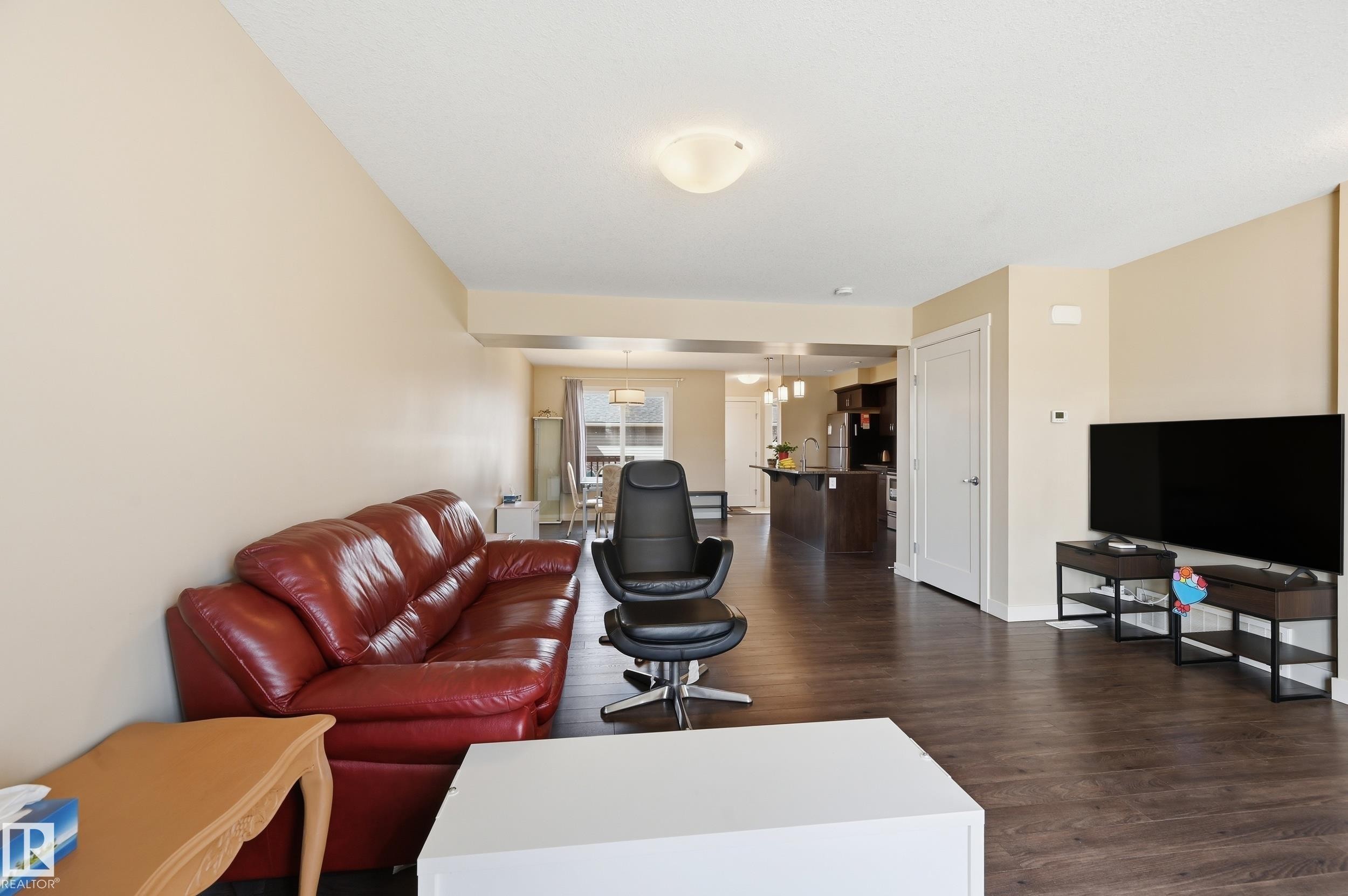 The property features light-colored walls and dark wood flooring - 701 Allard Boulevard, Edmonton, AB - Indoor Photo Showing Living Room