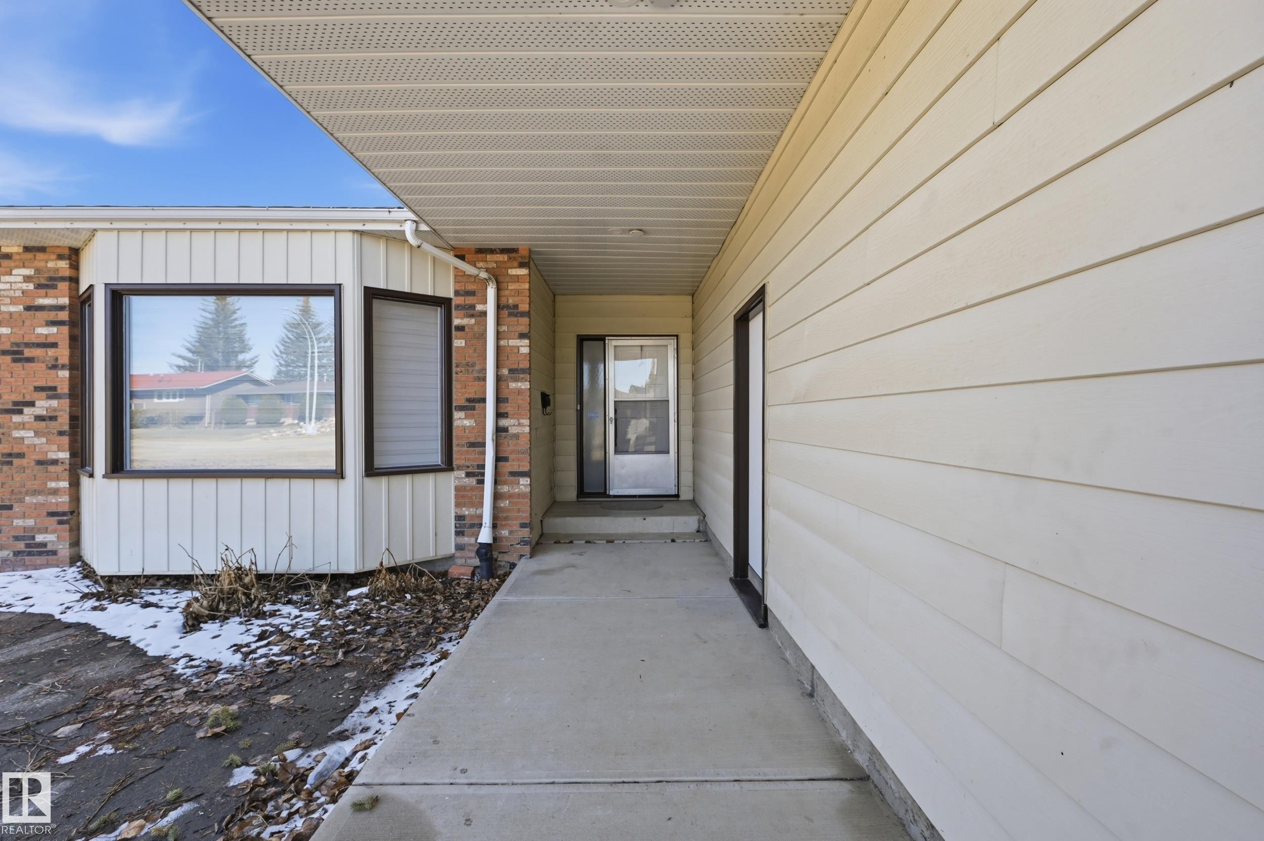The property features a concrete walkway leading to the entrance, a bay window, and a combination of brick and siding on its exterior - 6907 19 Avenue, Edmonton, AB - Outdoor With Exterior