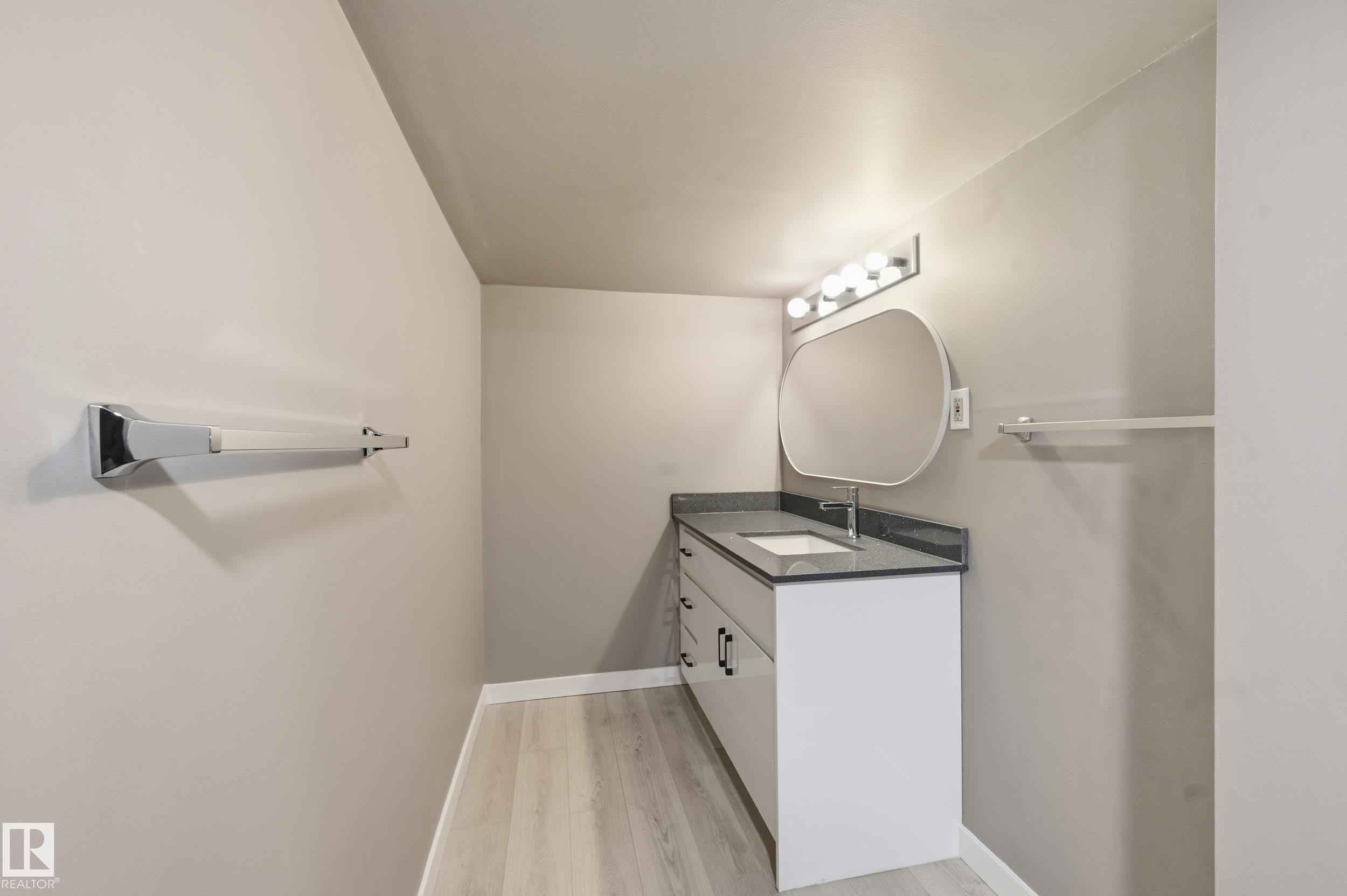Bathroom with a contemporary vanity, an oval mirror, and light-colored flooring - 6907 19 Avenue, Edmonton, AB - Indoor Photo Showing Laundry Room